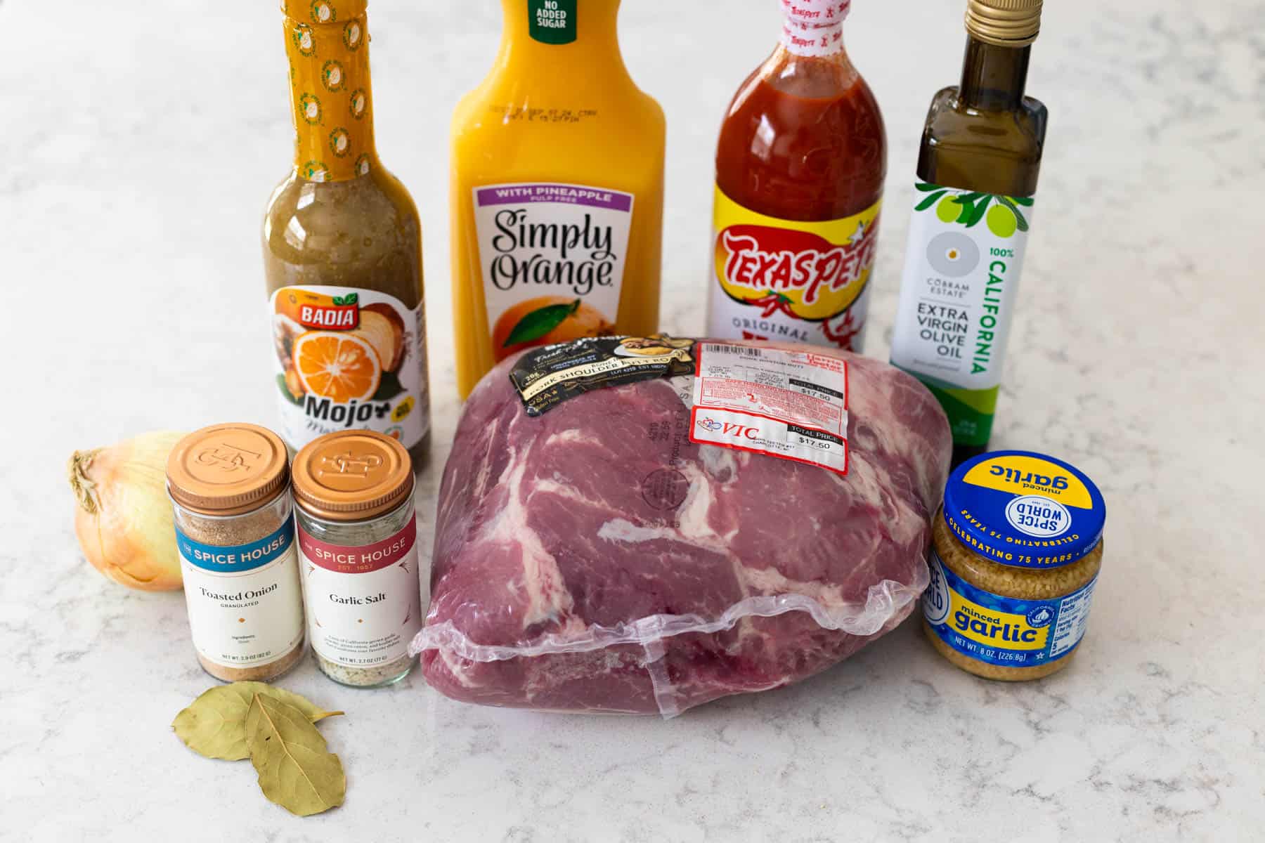 The ingredients to make a mojo Cuban pork shoulder are on the counter.