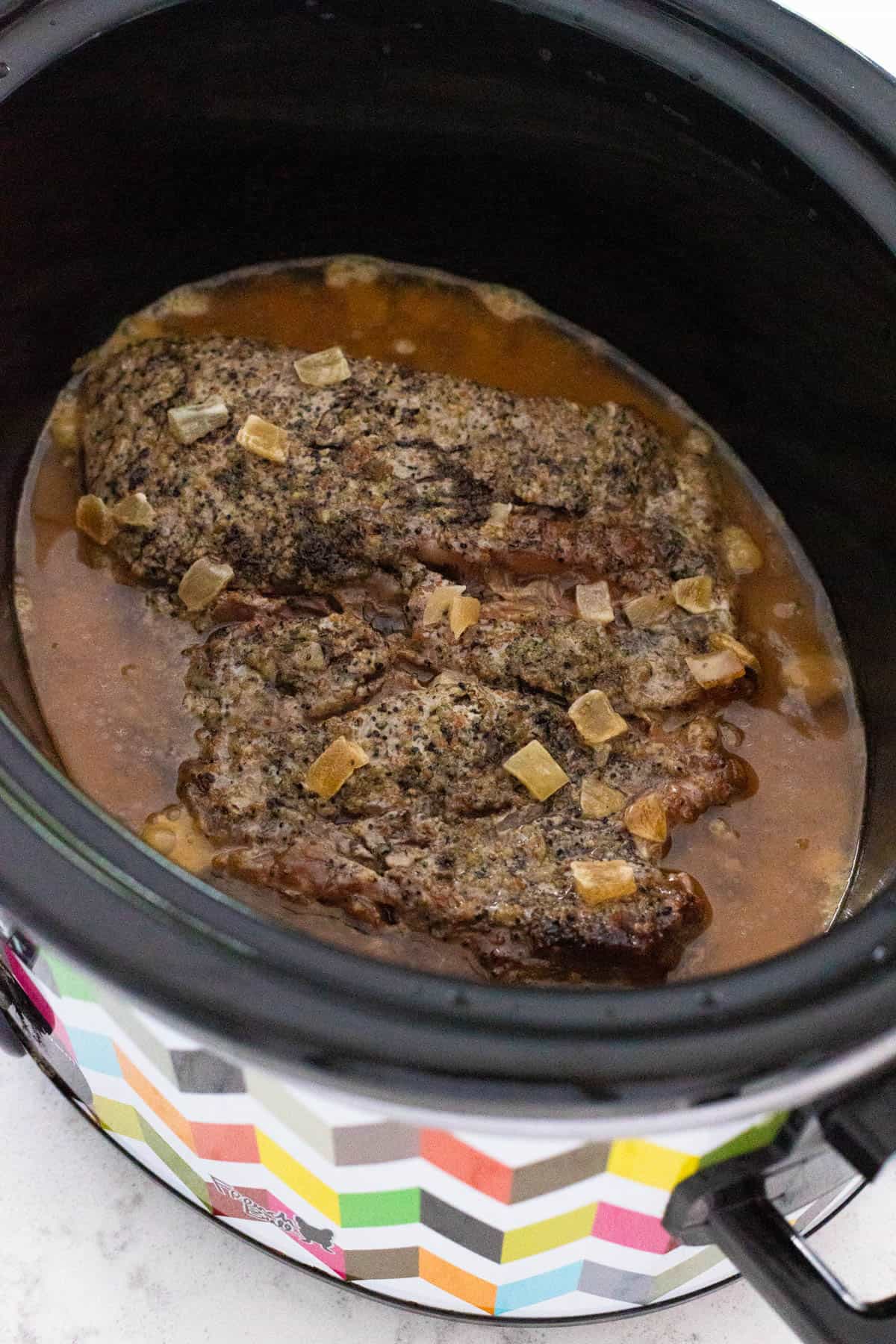 The beef has finished cooking in the crockpot.