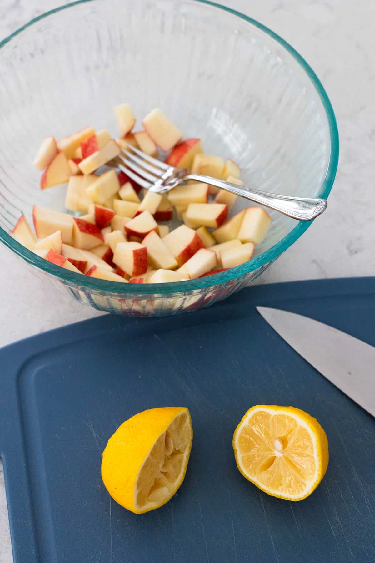 The lemon has been squeezed over the chopped apples to keep them crisp.