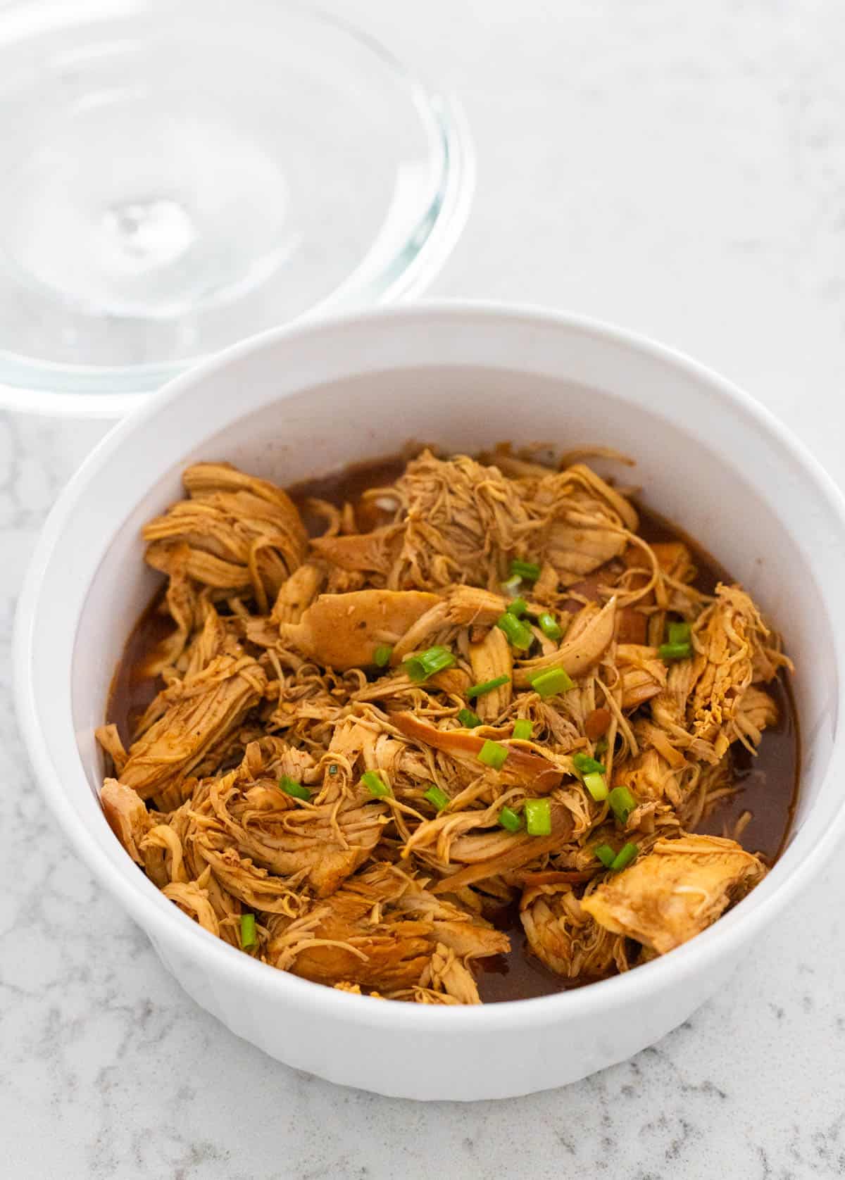 The cooked Hawaiian chicken sandwich filling has been spooned into a storage dish for the fridge.