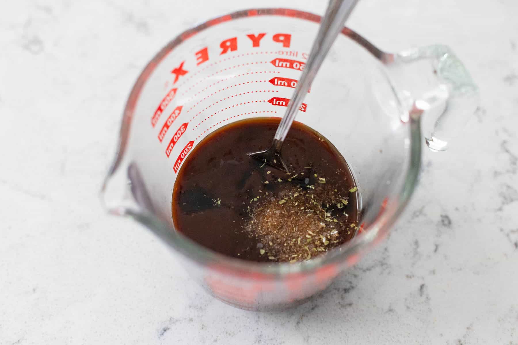 The soy sauce has been measured into a measuring cup and the dry seasonings have been added.