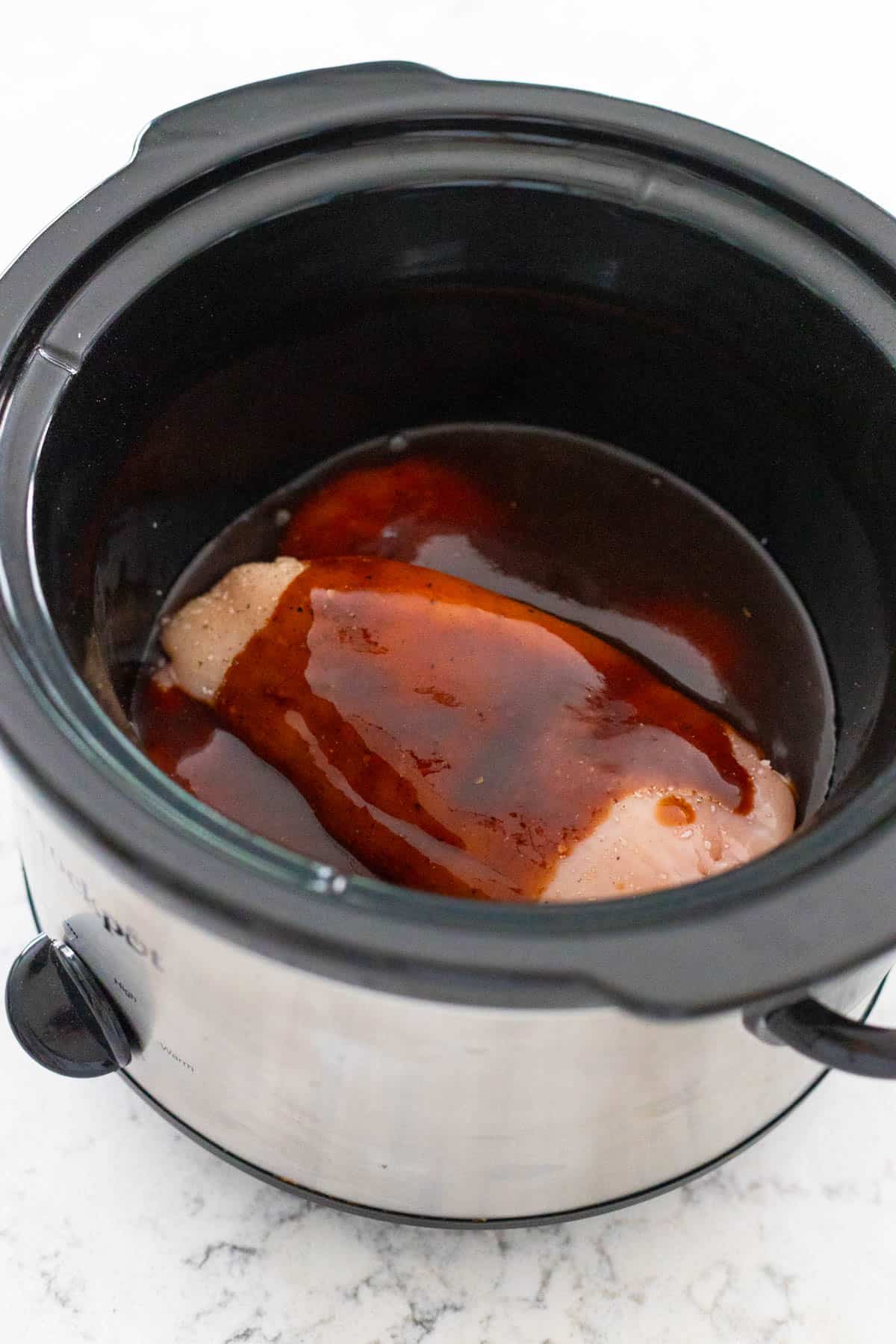 The prepped sauce has been poured over the chicken.