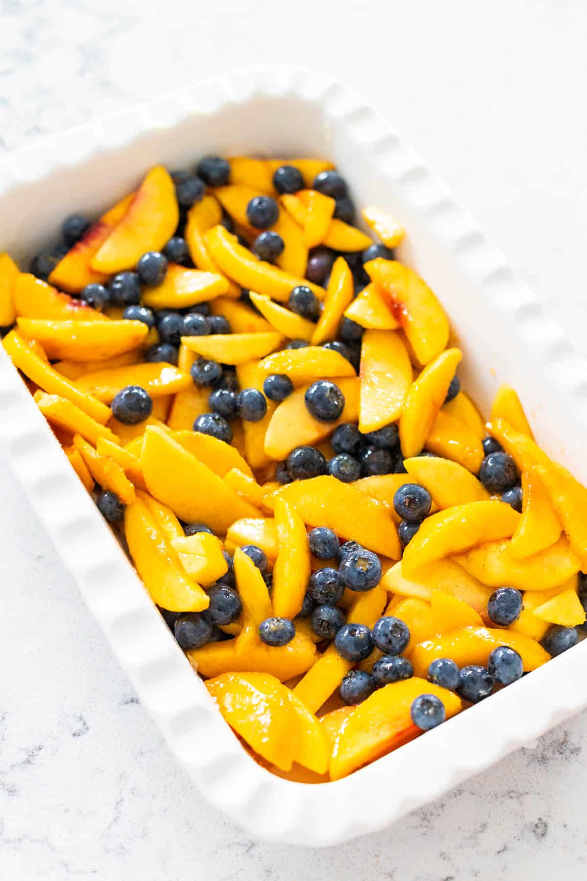 The baking dish has been filled with the prepared fruit filling.