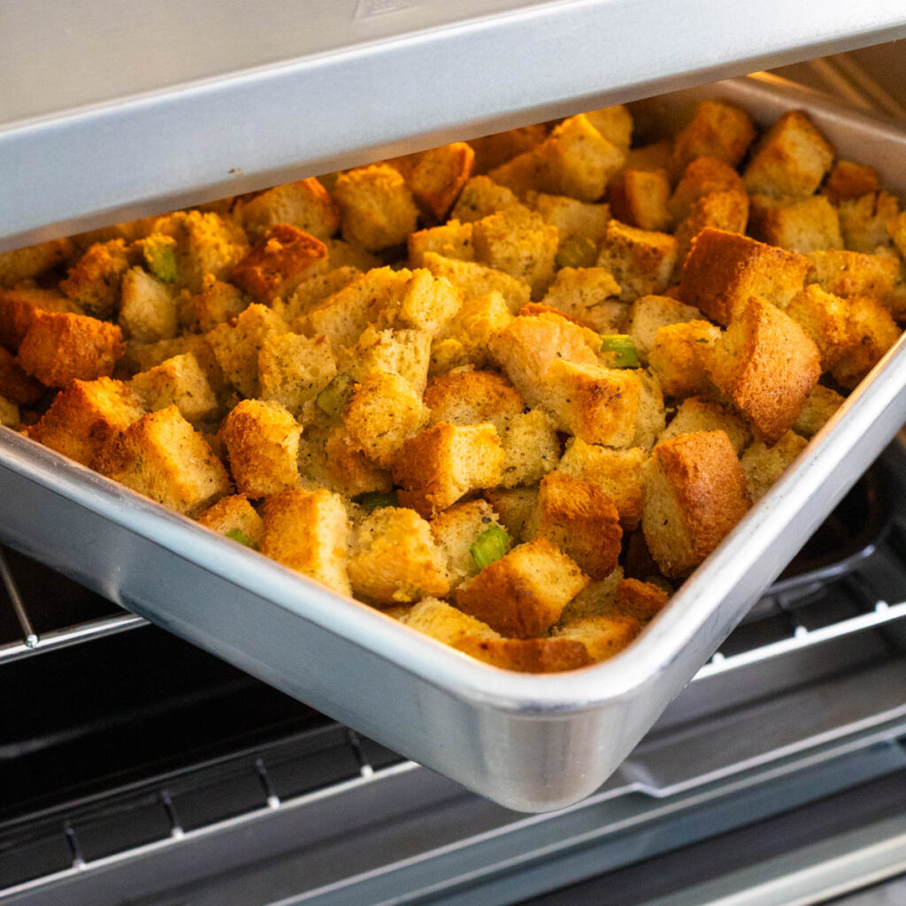 The pan of stuffing is coming out of the air fryer.