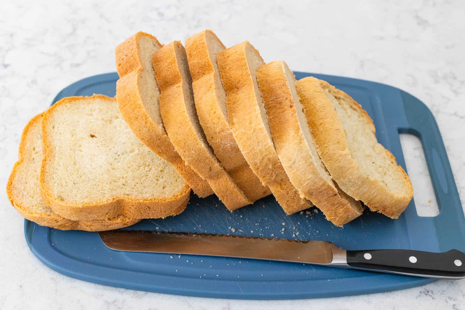 The loaf of bread has been sliced in 1-inch thick pieces.