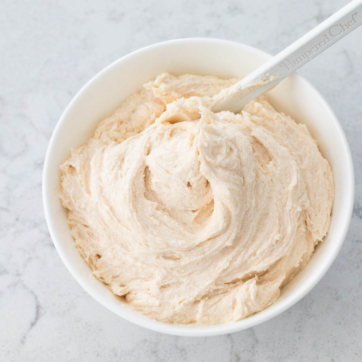 The browned butter frosting is in a white bowl.