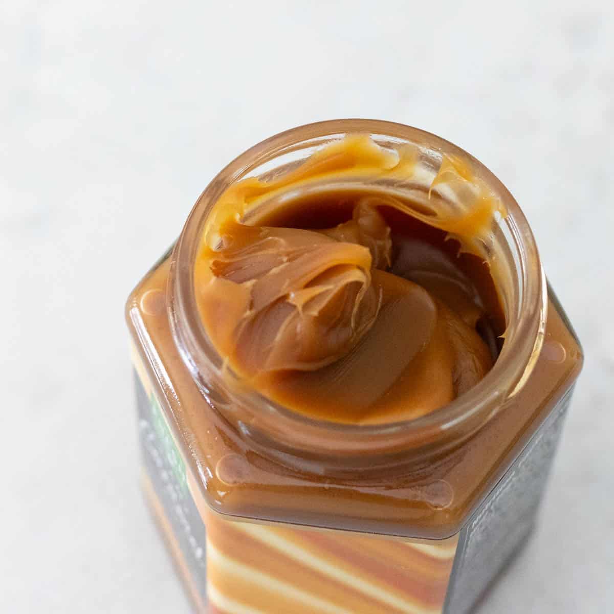 The jar of caramel sauce shows the very thick texture that is almost spreadable.