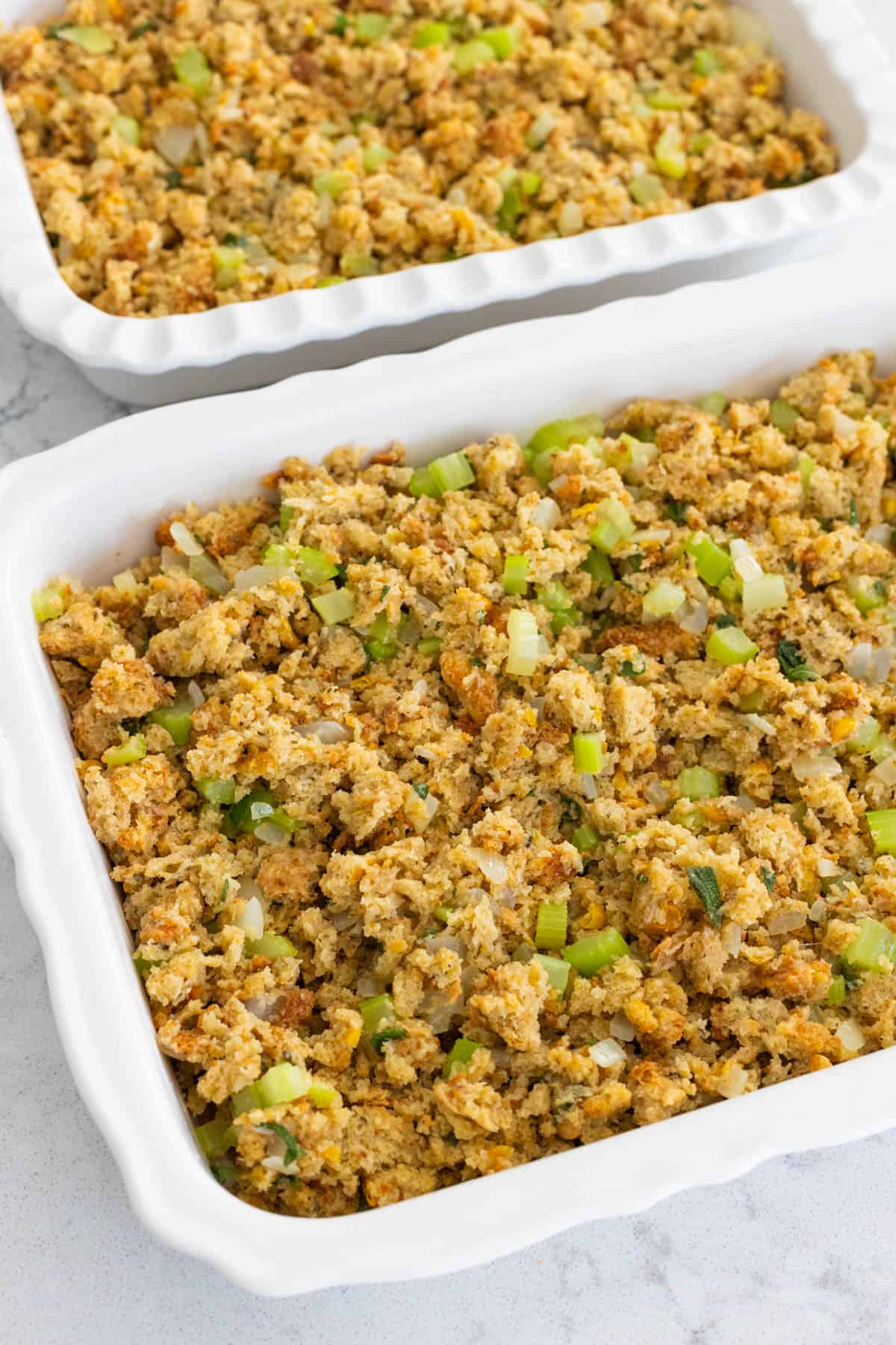 The mixed dressing has been spread into two baking dishes.