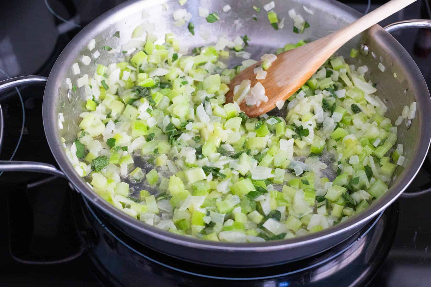 The celery and onions have been softened in a large skillet with melted butter.