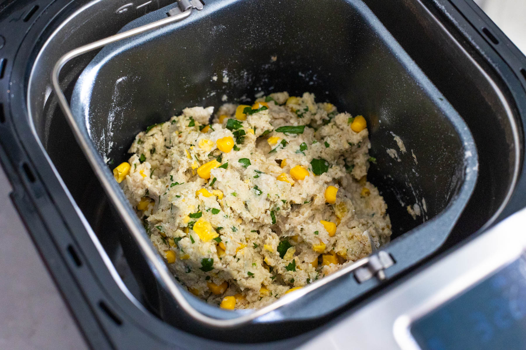 The bread dough is very thick, you can see the corn and fresh parsley.