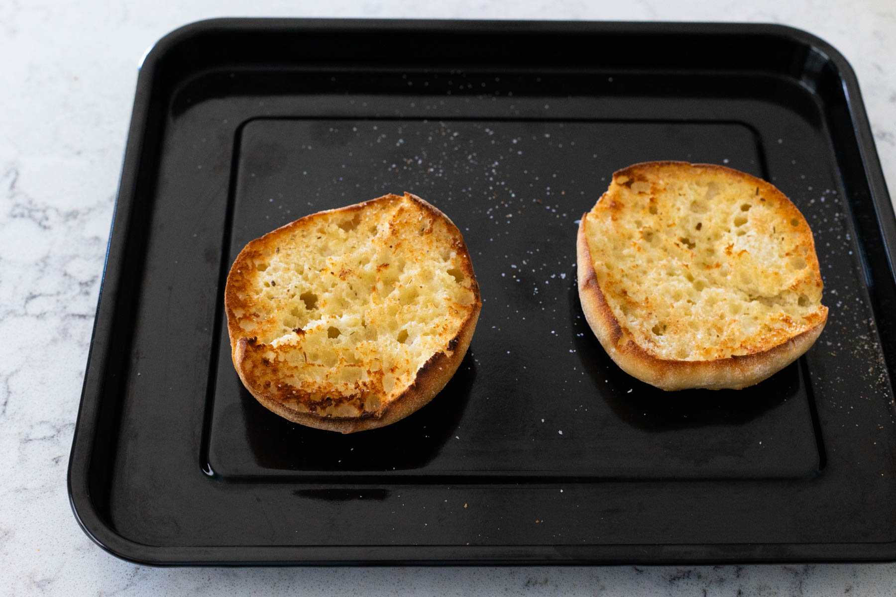 The crusty bun has been spread with butter and toasted under the broiler.
