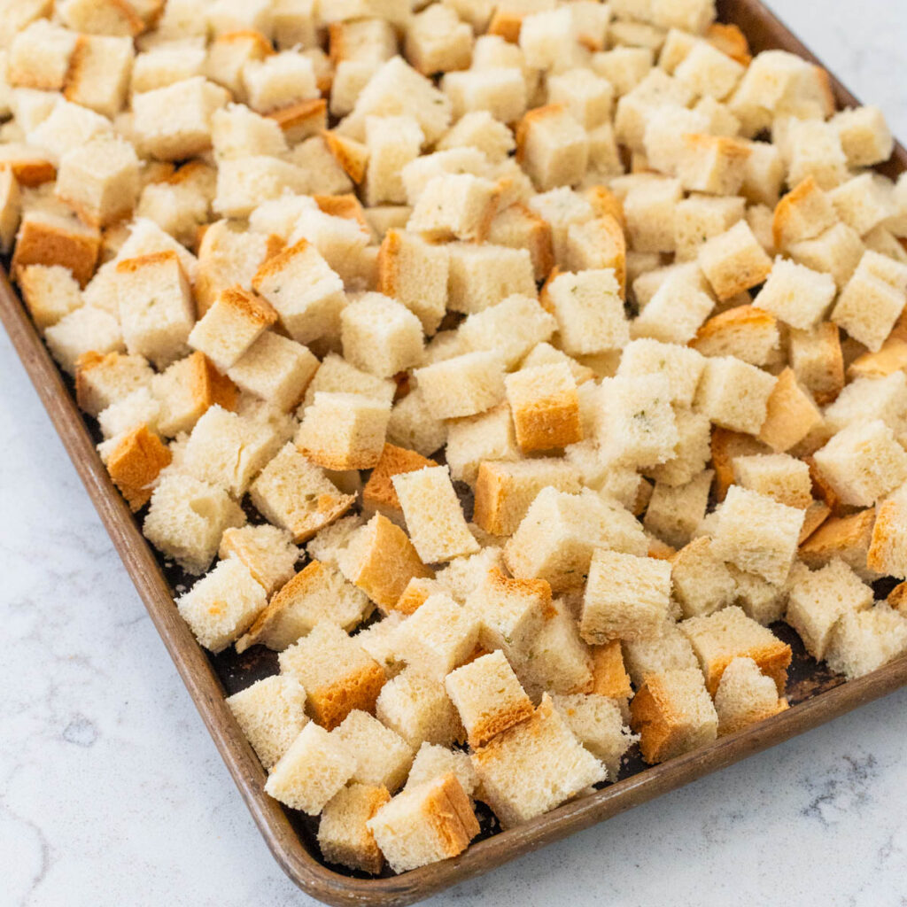 A baking sheet filled with cubed bread for baking into croutons to make stuffing.