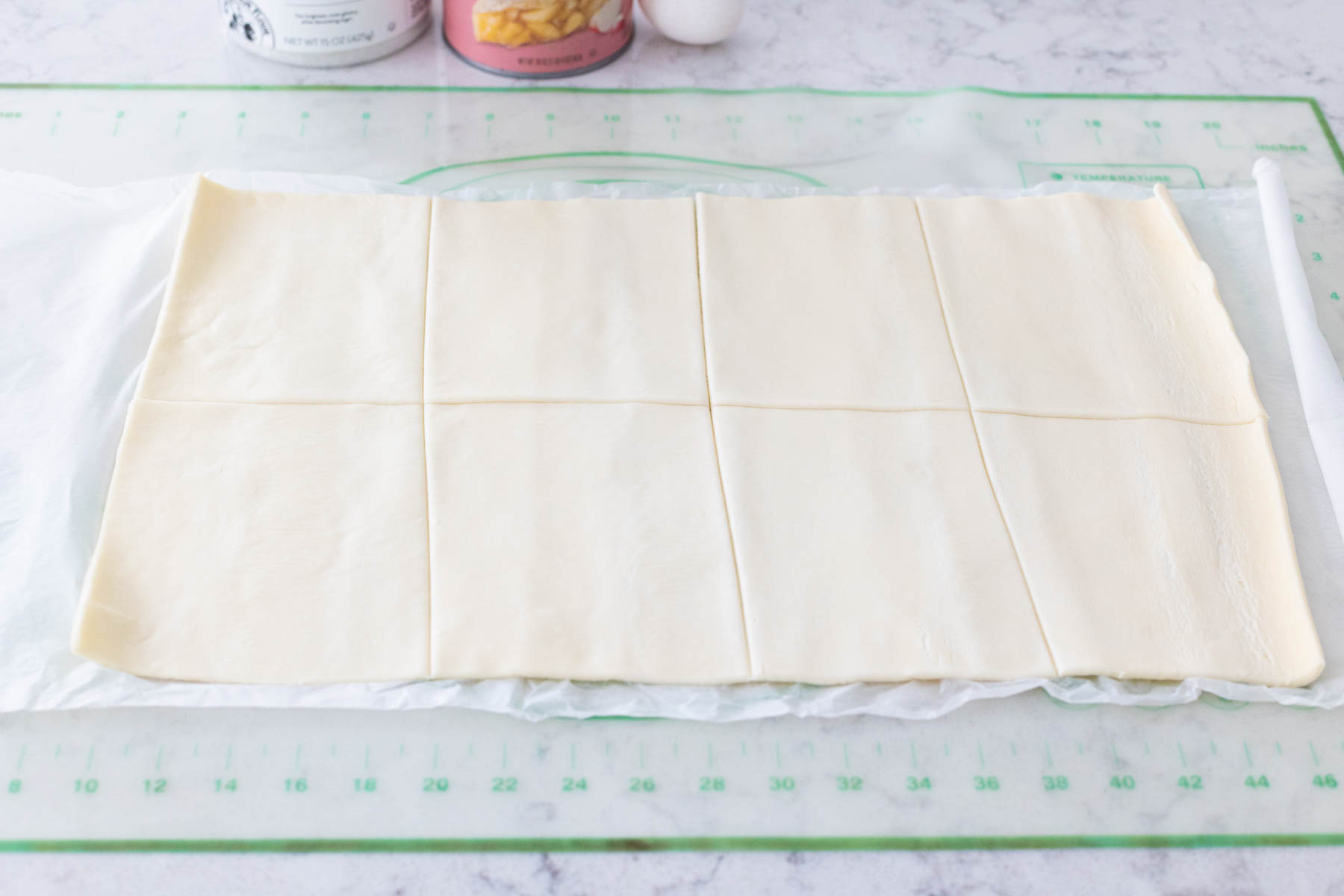 The sheet of pastry has been cut into 8 equal squares.