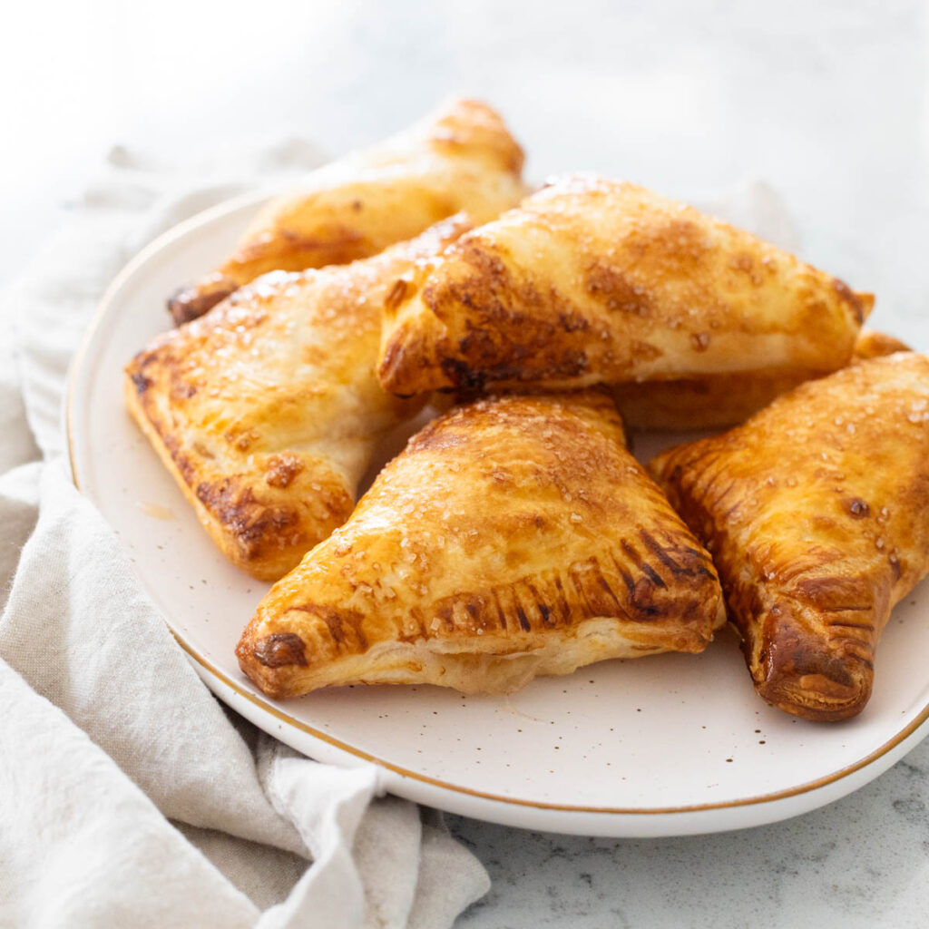 A platter of golden brown apple turnovers.