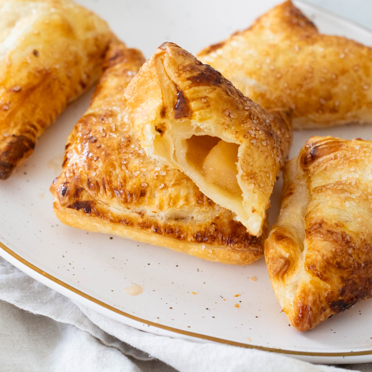 The pastry has a bite taken out of it so you can see the apple filling inside.