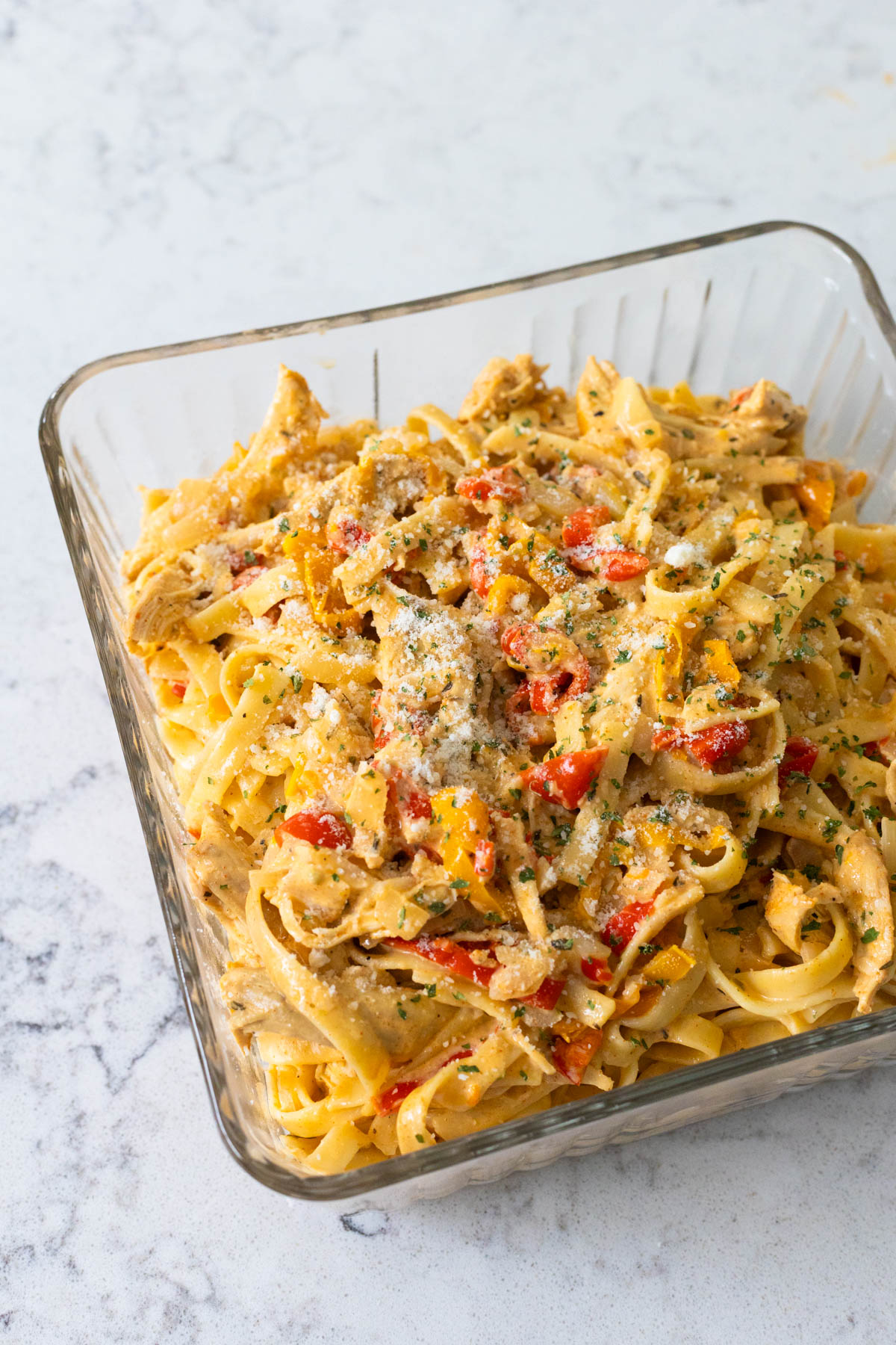 The chicken pasta is in a square storage dish ready to go in the fridge.