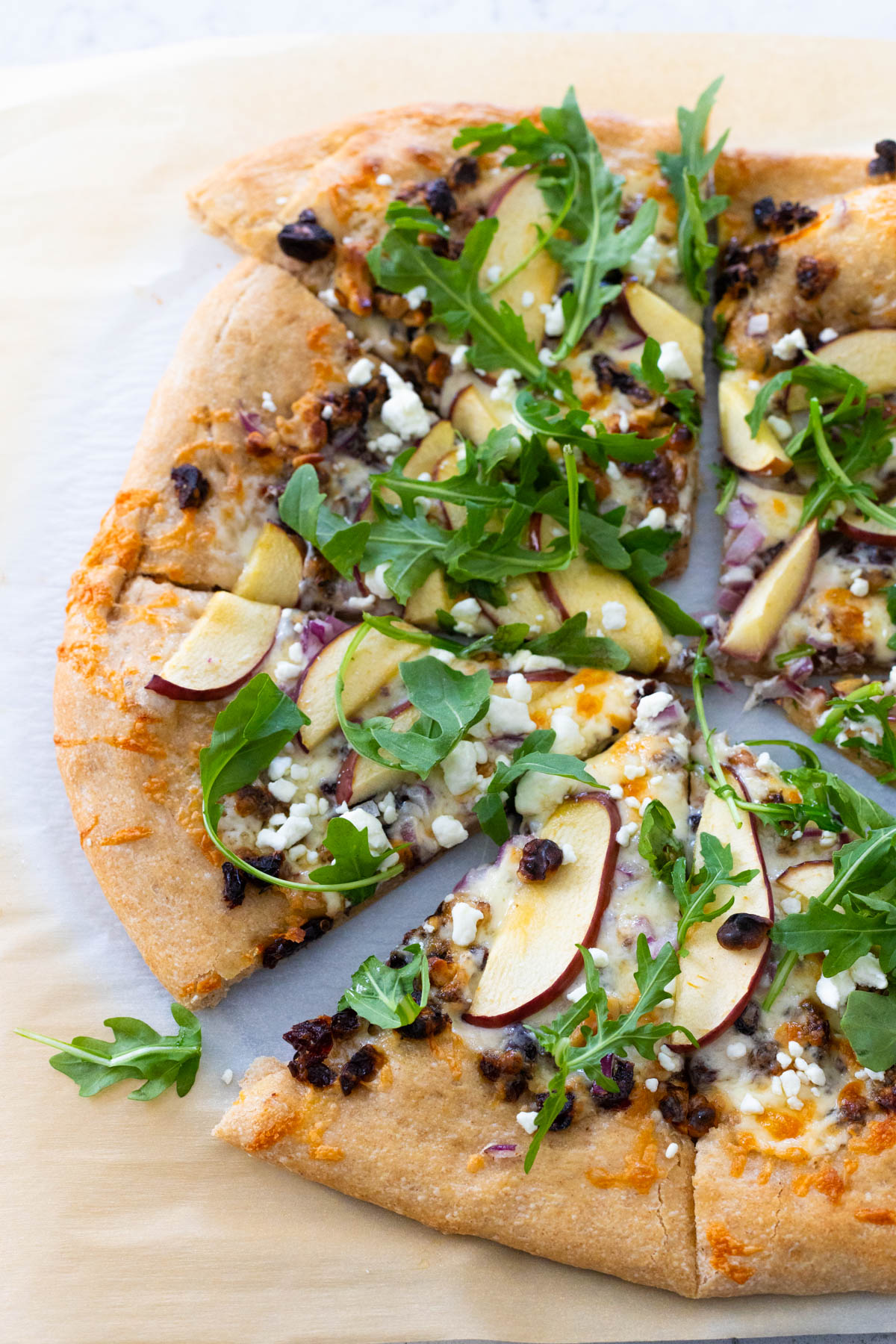The savory apple pizza has fresh arugula and cranberries on a whole wheat crust.