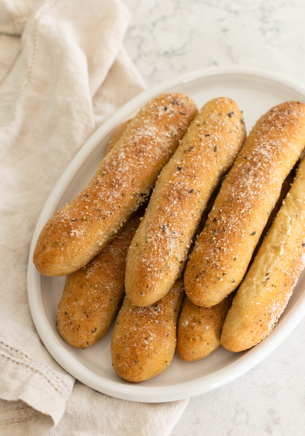The breadsticks are served at dinner on a white platter.