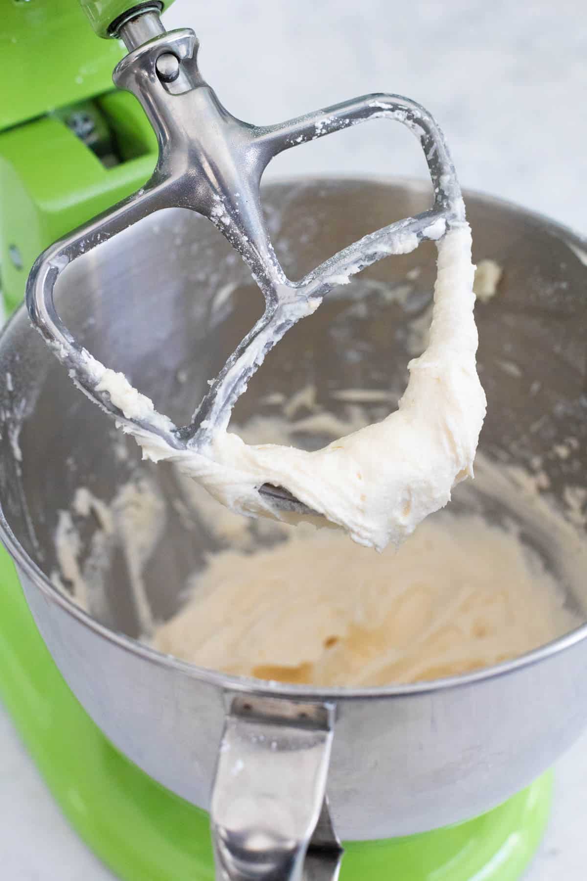 The frosting clings to the stand mixer paddle.