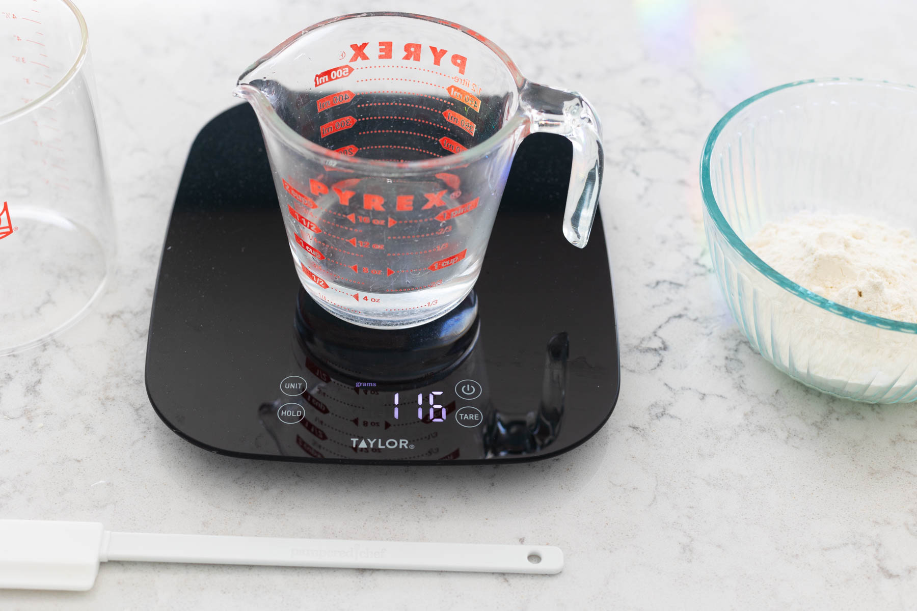 The measuring cup sits on the food scale.