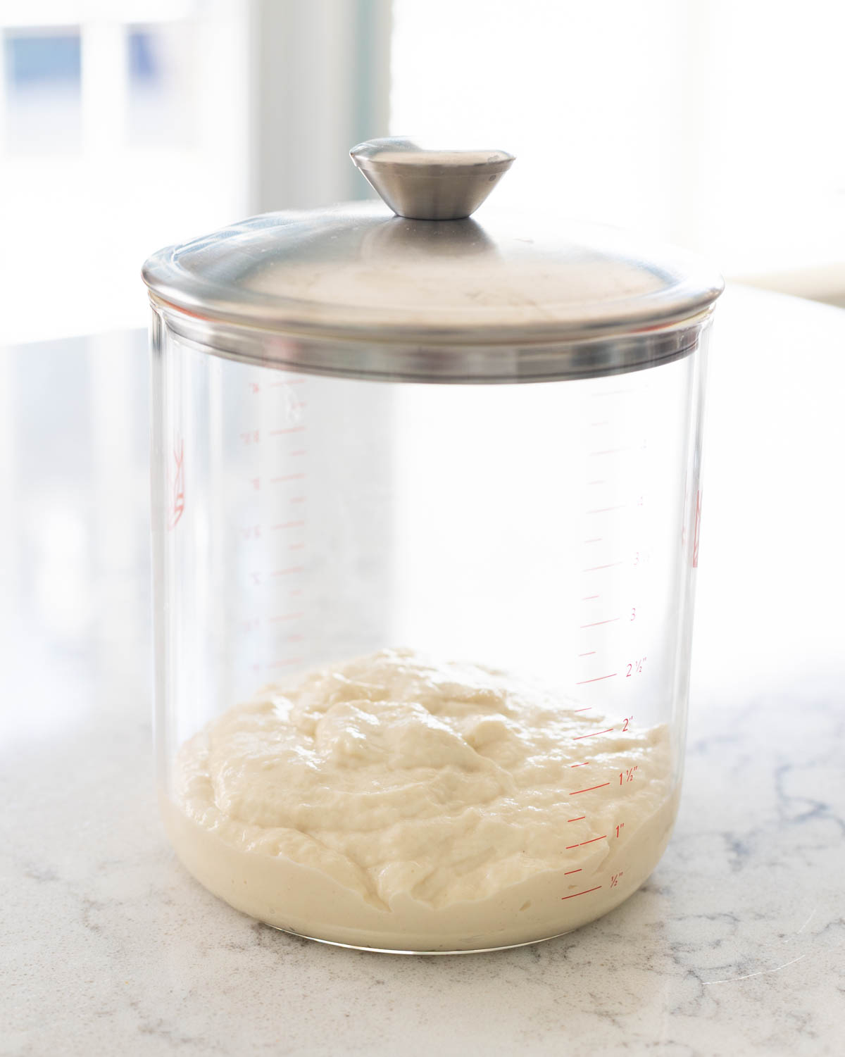 The freshly fed sourdough starter has been added to a storage jar.