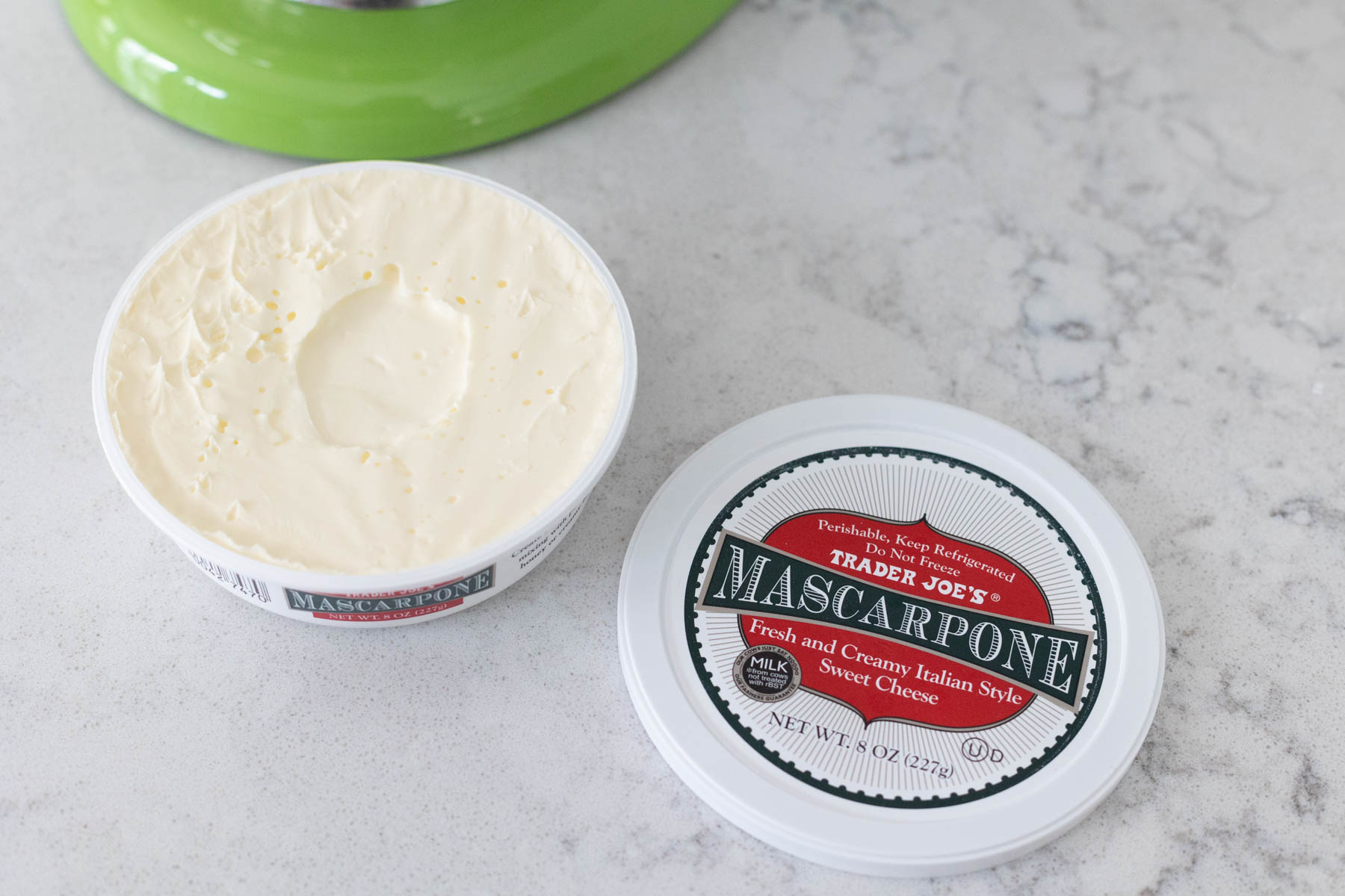 A container of mascarpone cheese is on the counter.