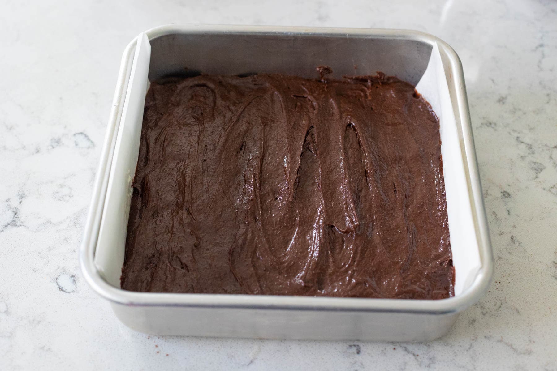 The second half of the brownie batter has been smoothed over the top.