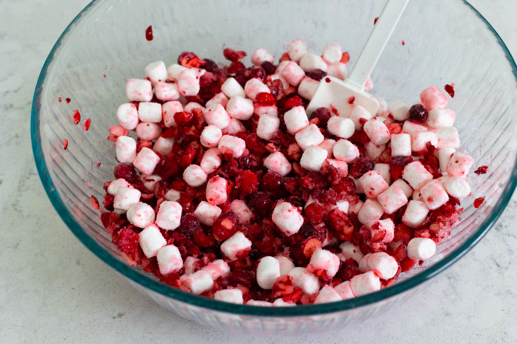 The cranberries, sugar, and marshmallows are in a large mixing bowl waiting for the fridge.
