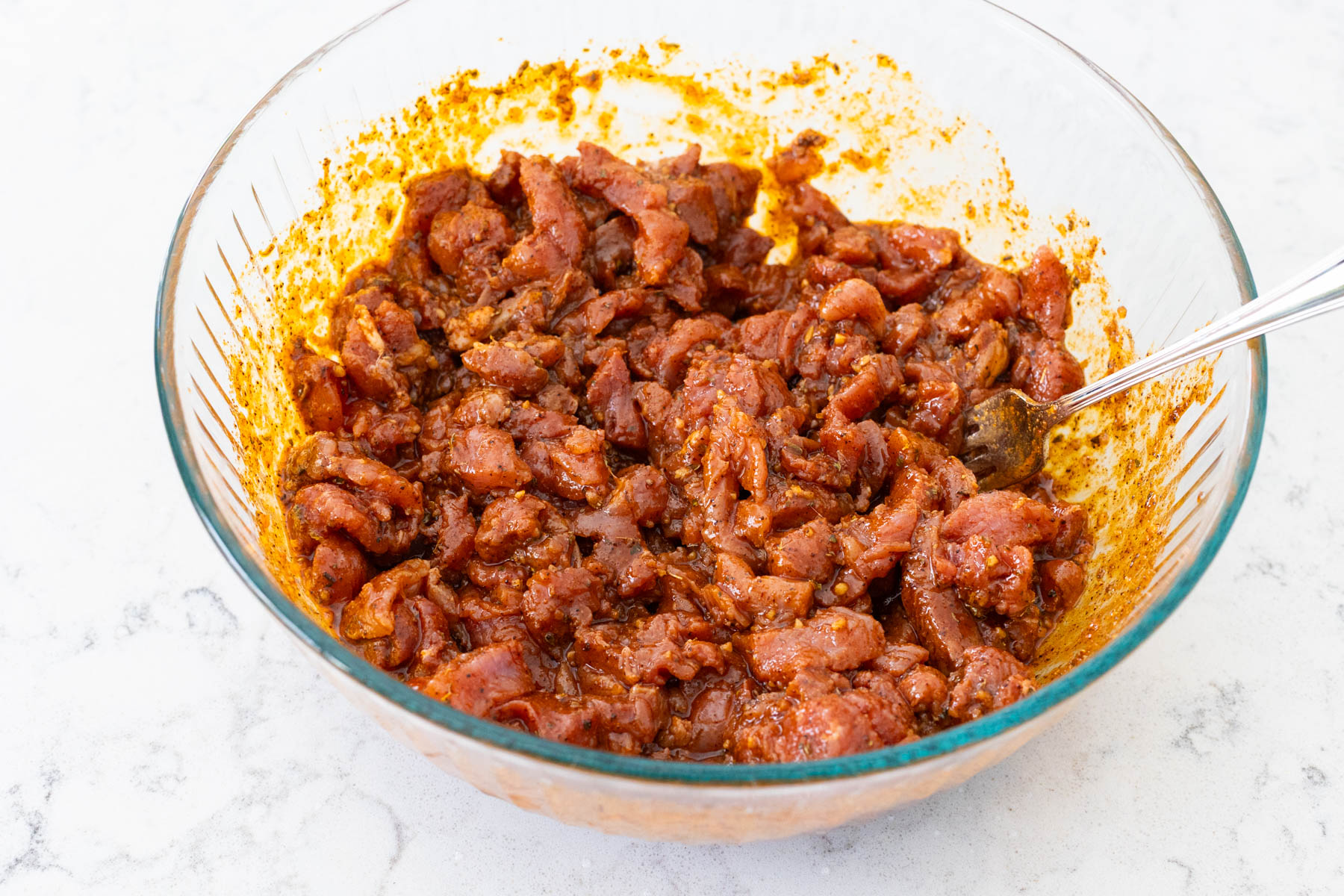 The sliced pork has been tossed in the marinade and is ready to rest in the fridge.