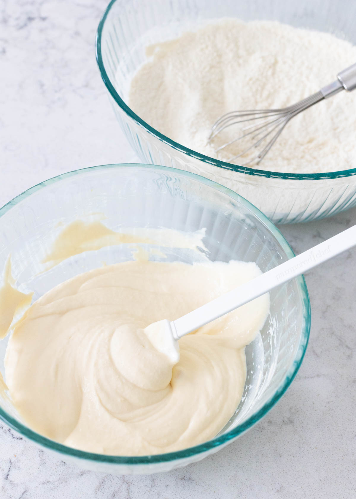 One bowl of dry ingredients and one bowl of wet ingredients are about to be mixed together for the muffin batter.