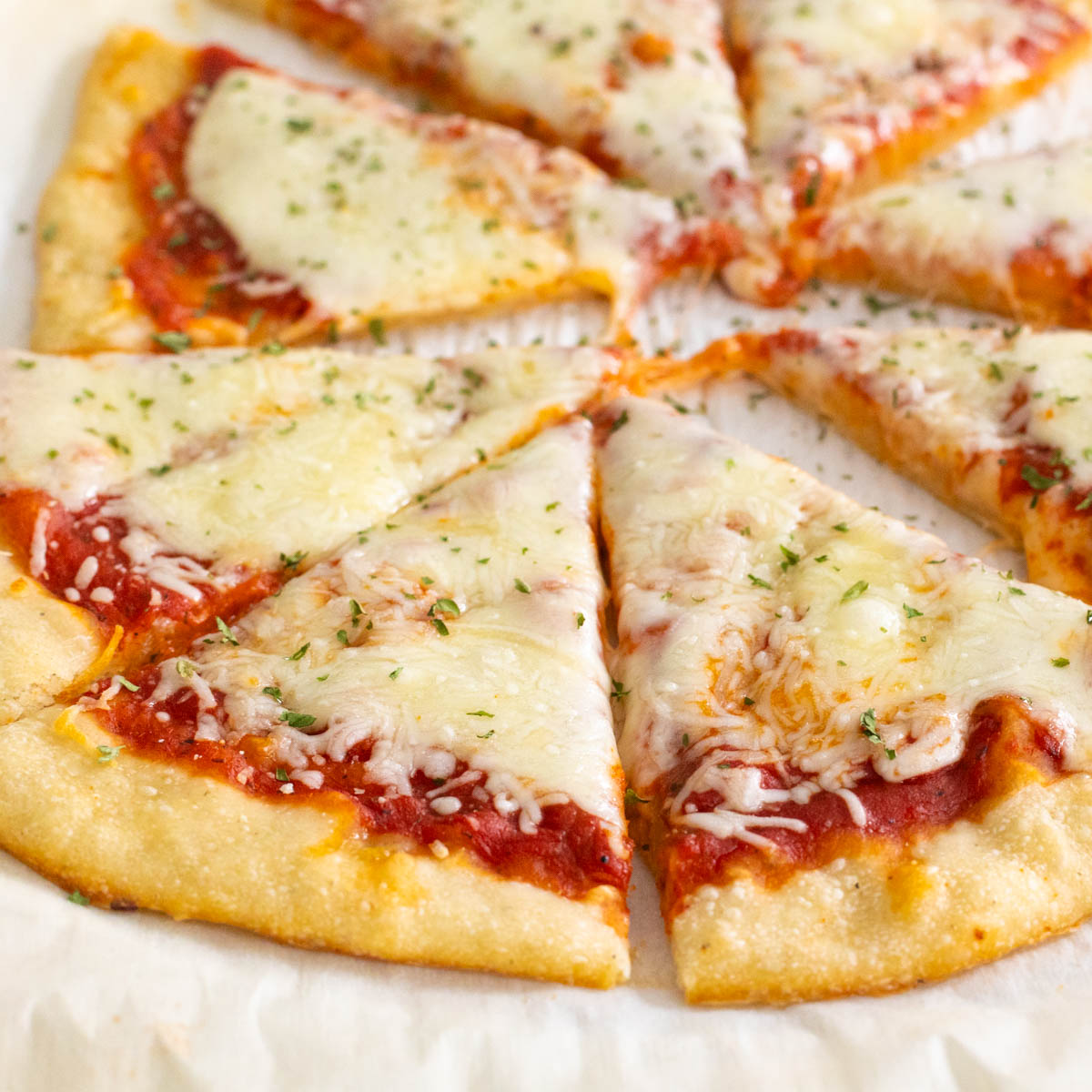 A plain cheese pizza with tomato sauce has been baked with a sourdough discard crust that is now golden brown.