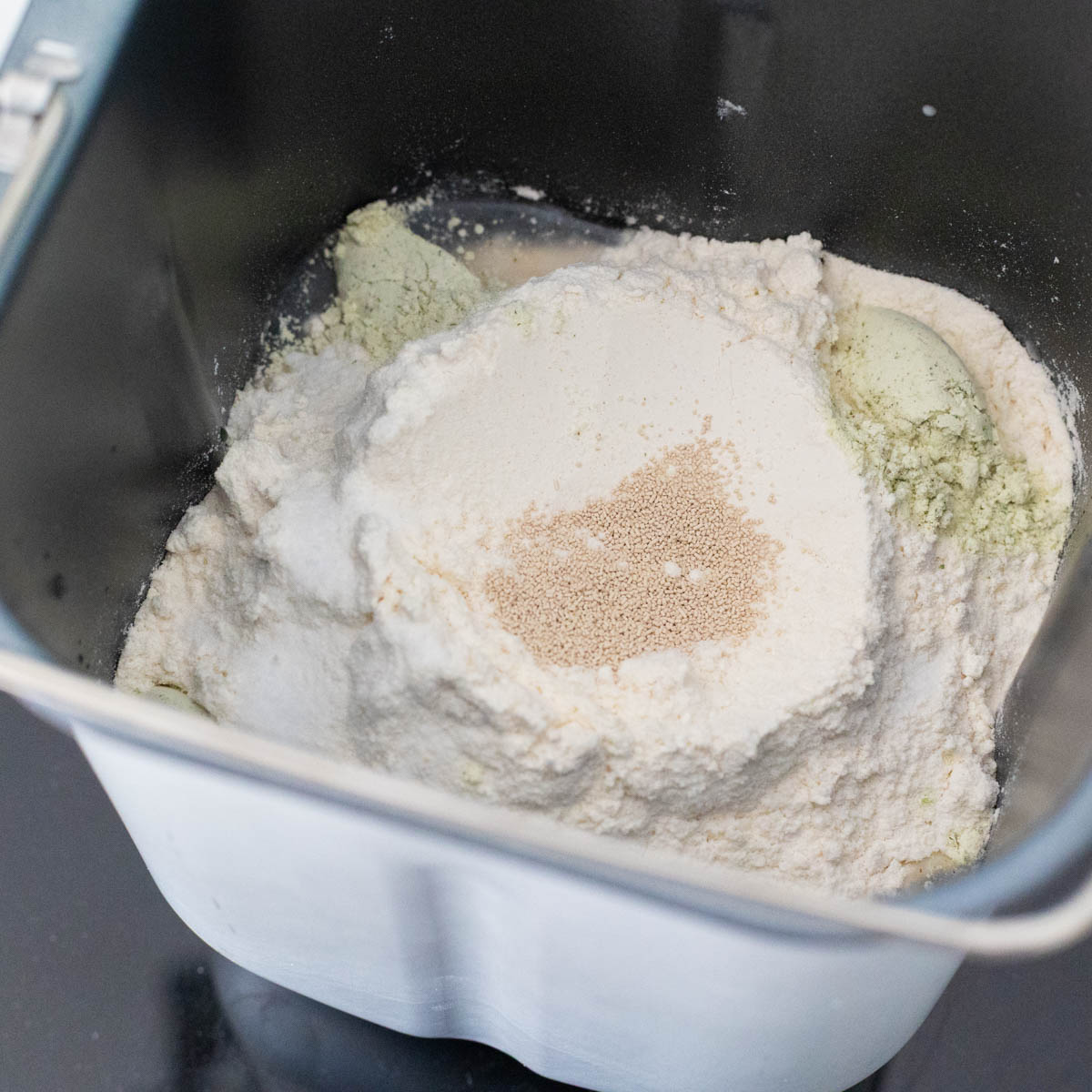 The dry ingredients are in the bread machine pan fitted with the paddle attachment.