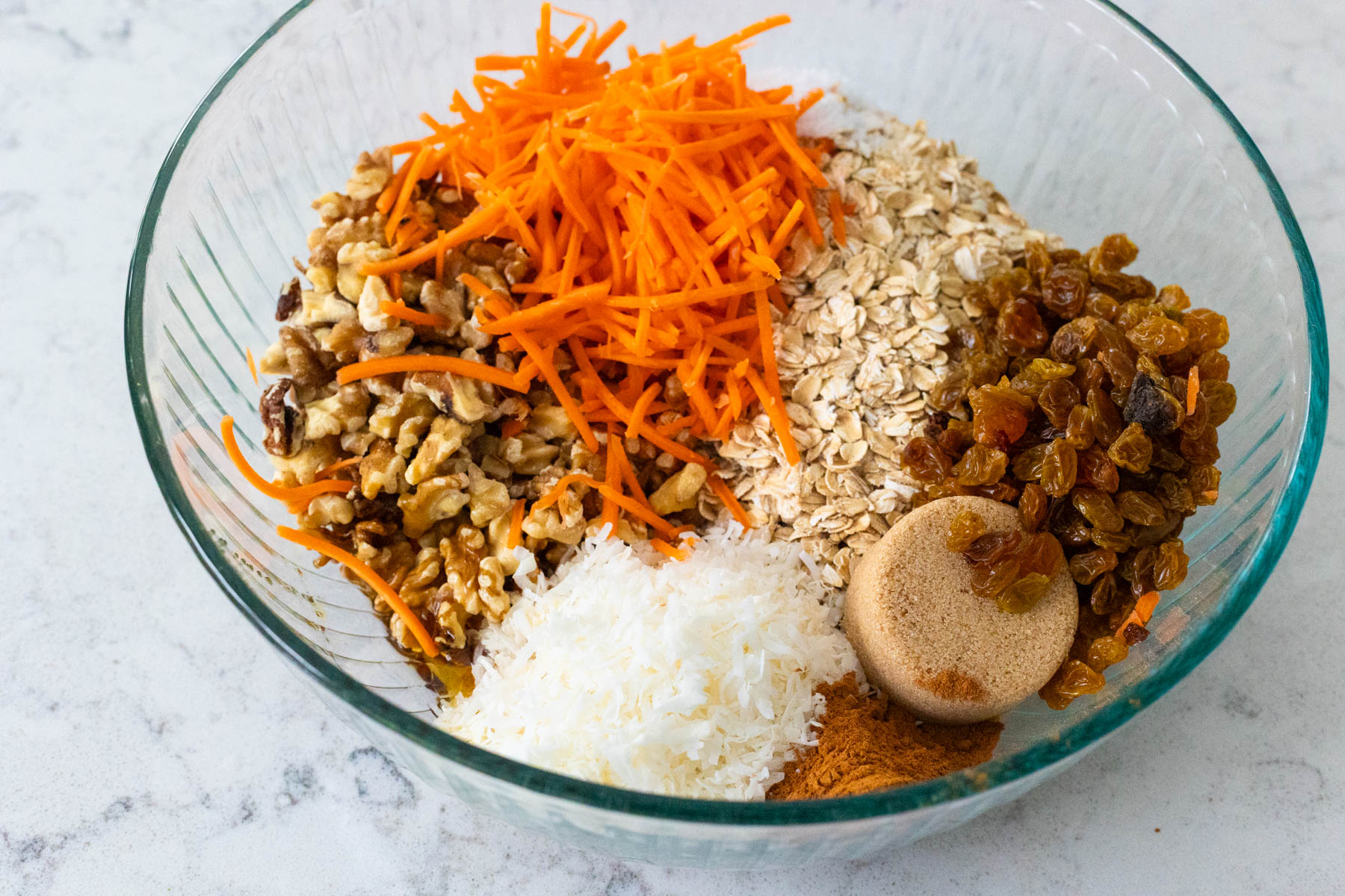 The granola ingredients have been measured into a large mixing bowl.