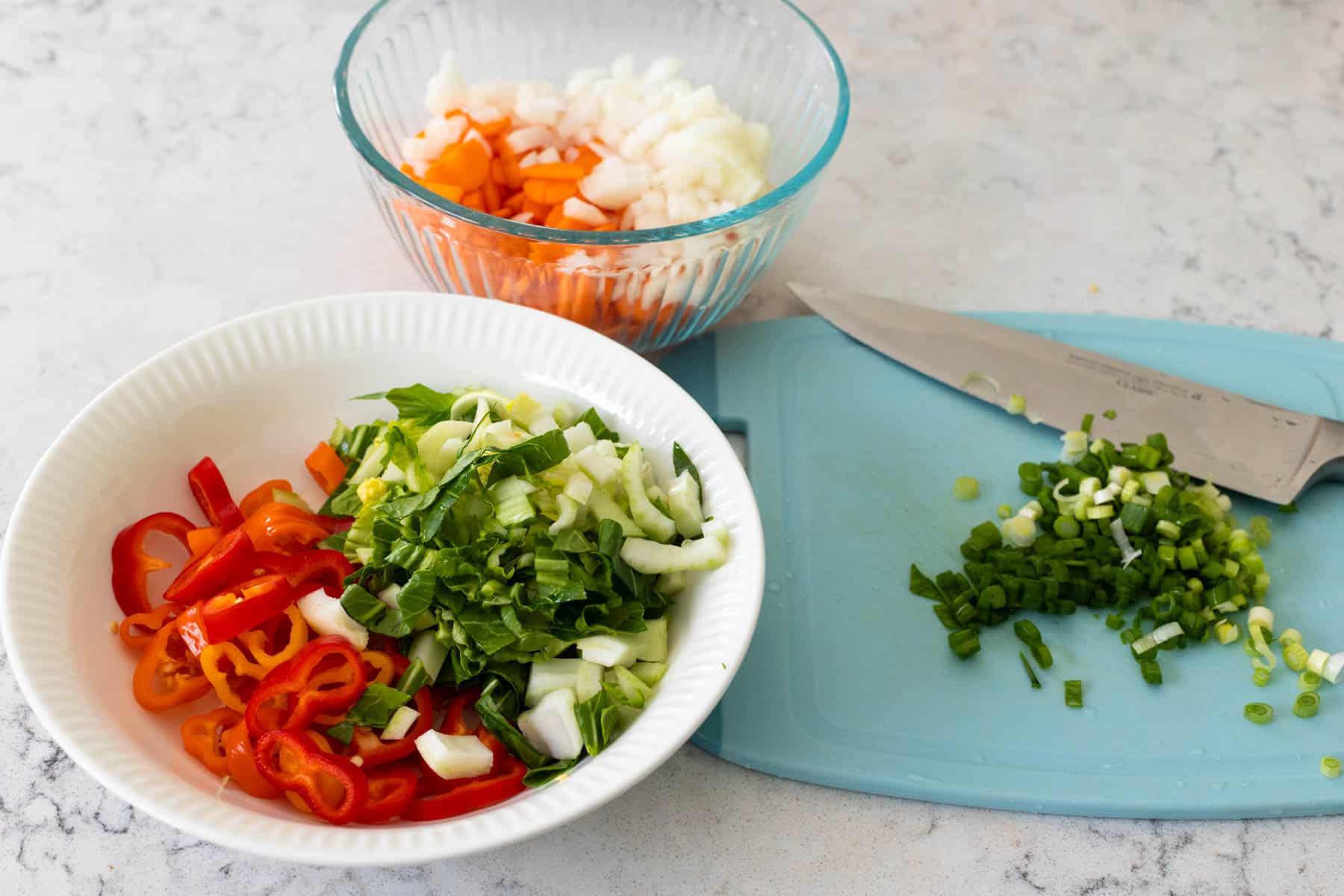 The vegetables have been chopped and portioned out into separate mixing bowls for easy cooking.