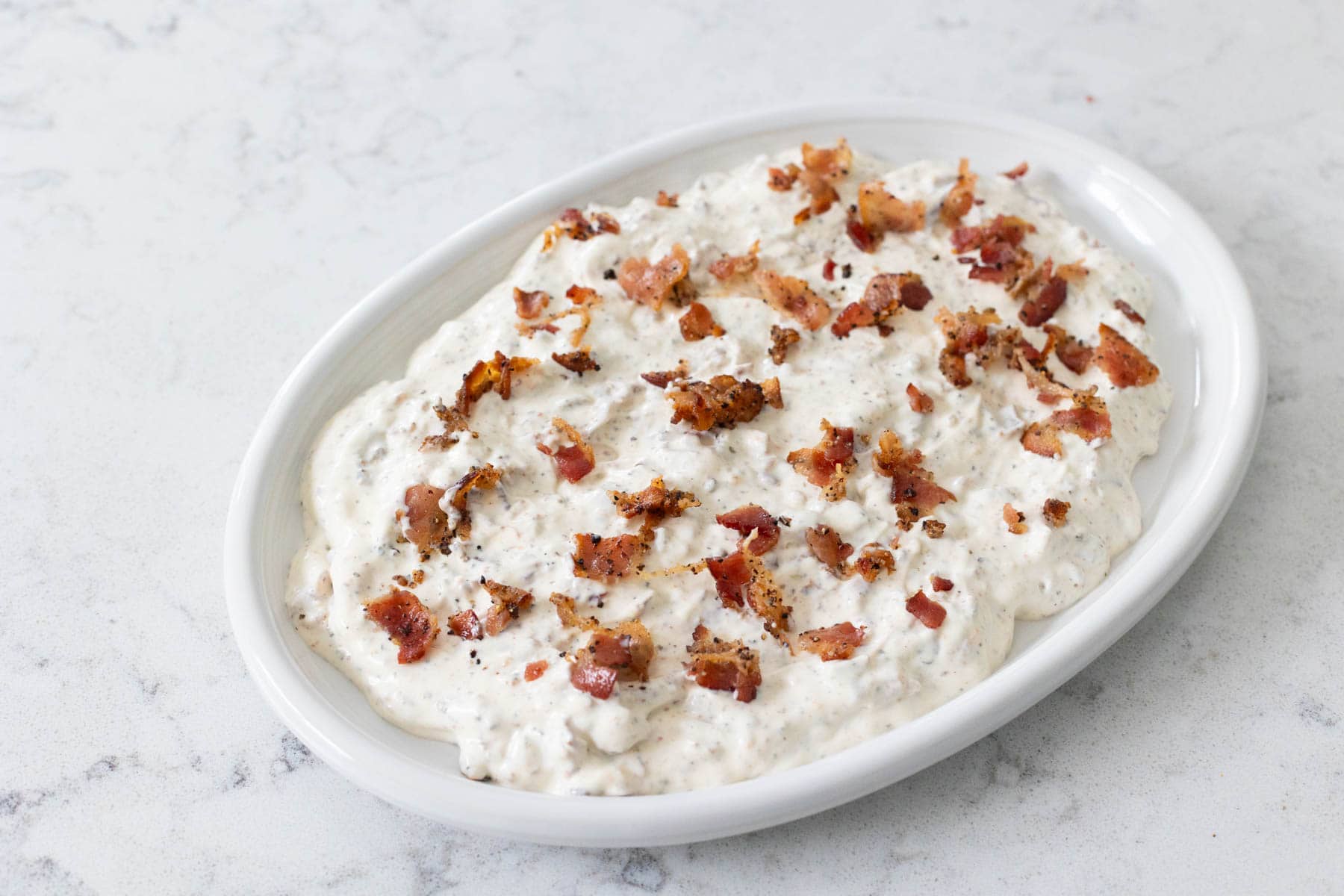 The creamy dip layer has been spread into a layer and is now going into the fridge to chill.