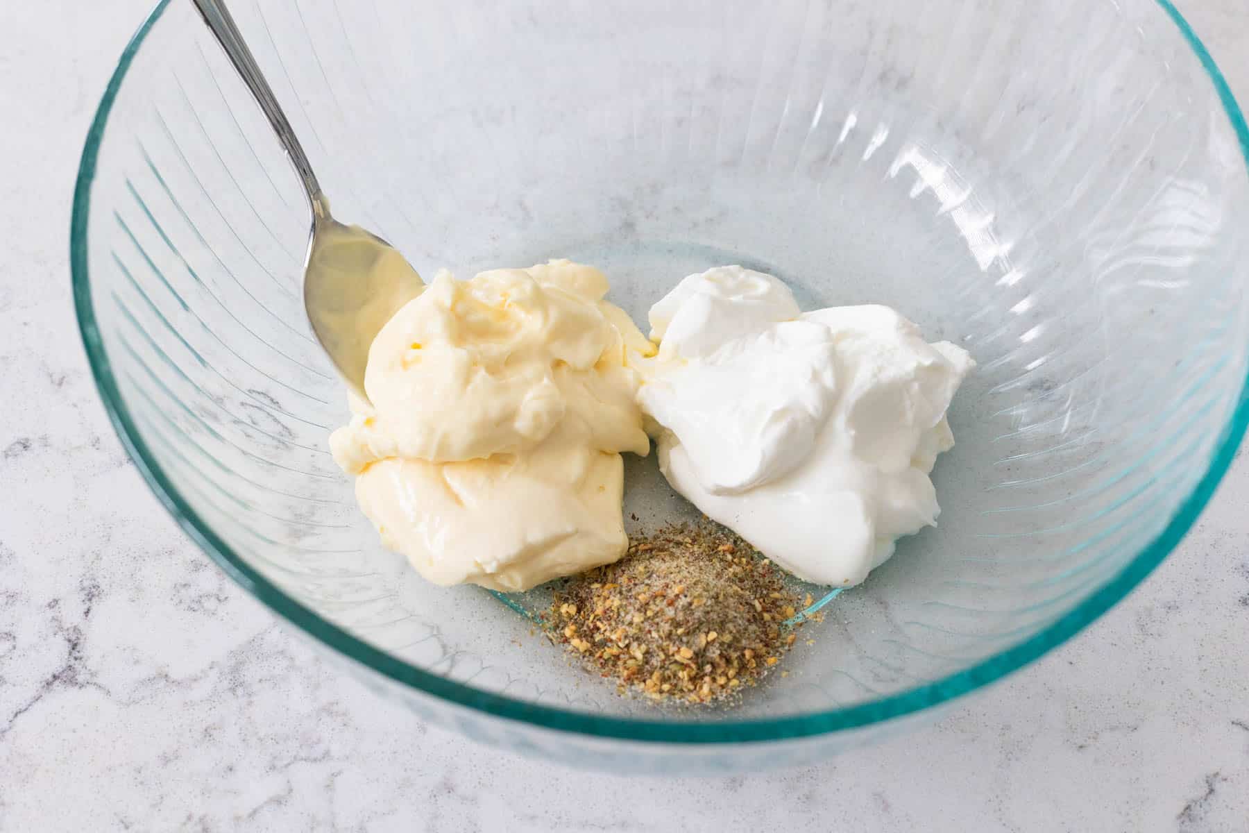 The mixing bowl had mayonnaise and sour cream with Italian seasoning.