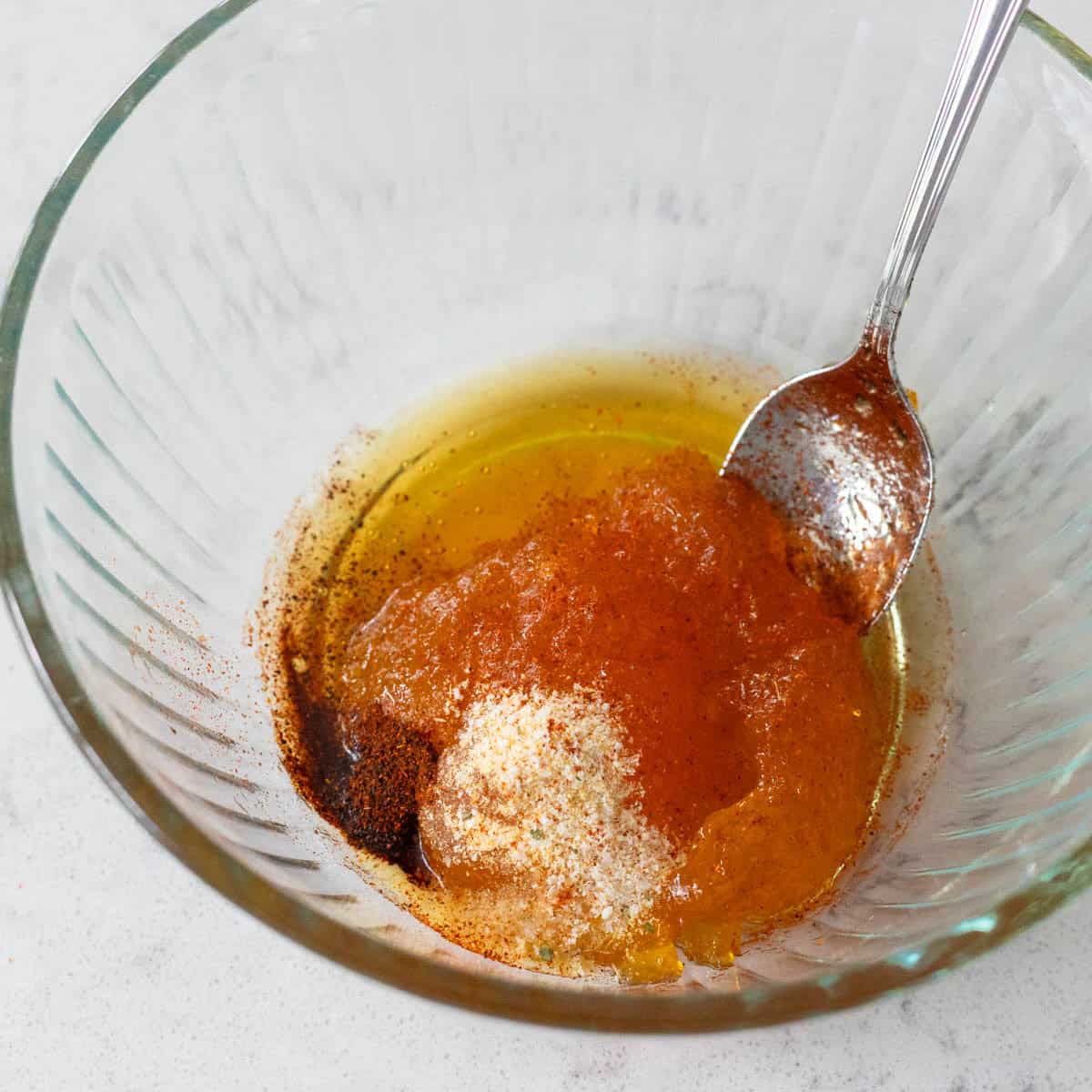 The ingredients to make the peach glaze are in a small mixing bowl.