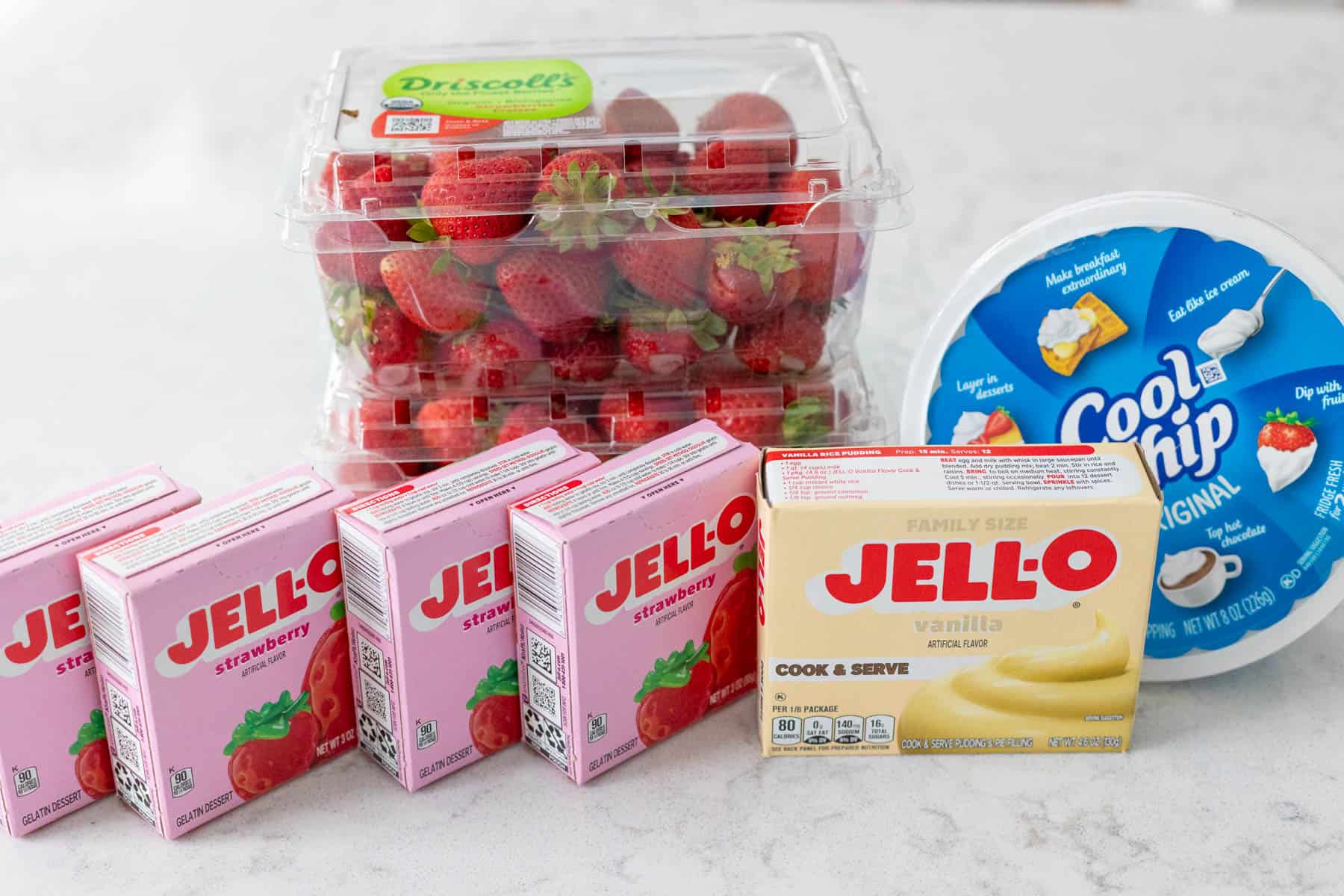 Les ingrédients pour faire la salade de Jell-O aux fraises sont sur le comptoir de la cuisine.