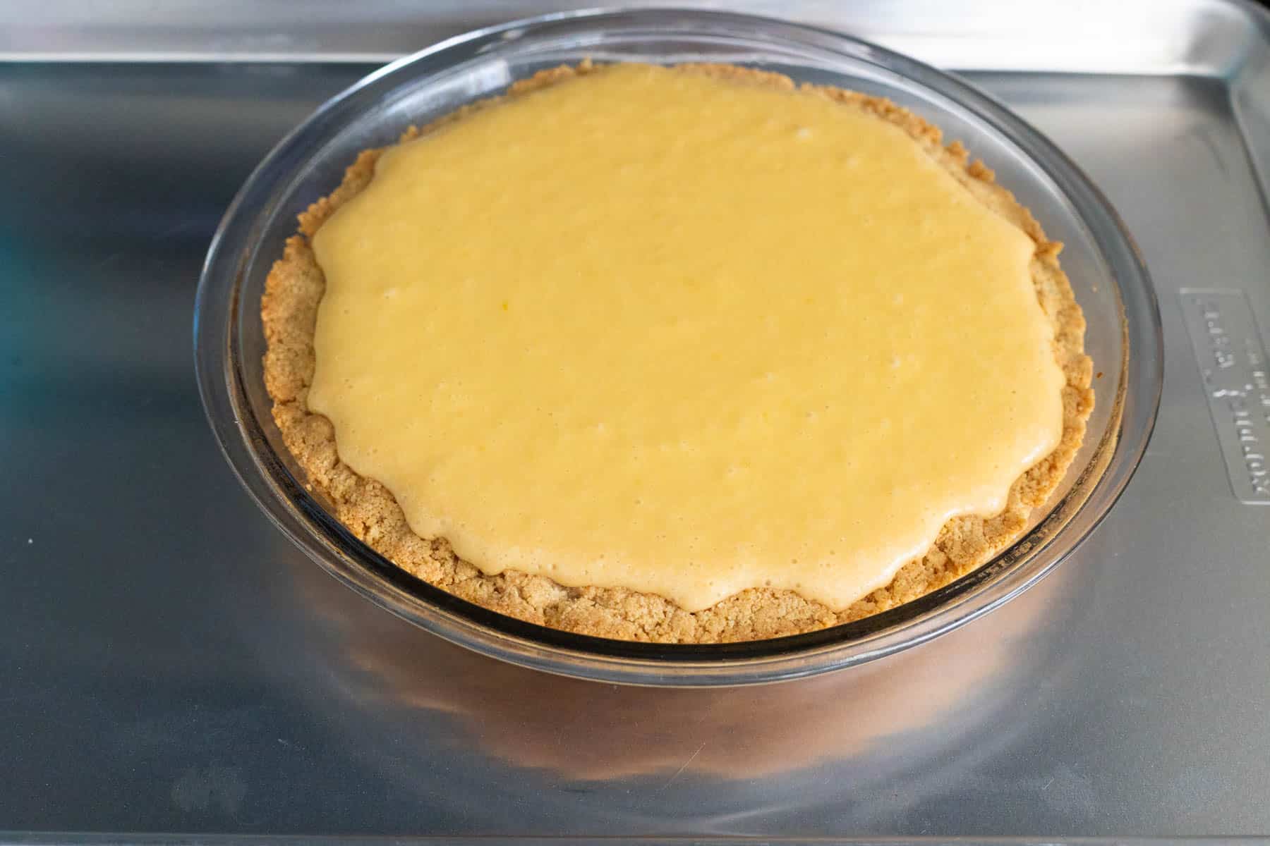 The baked lemon. pie is cooling on the stovetop.