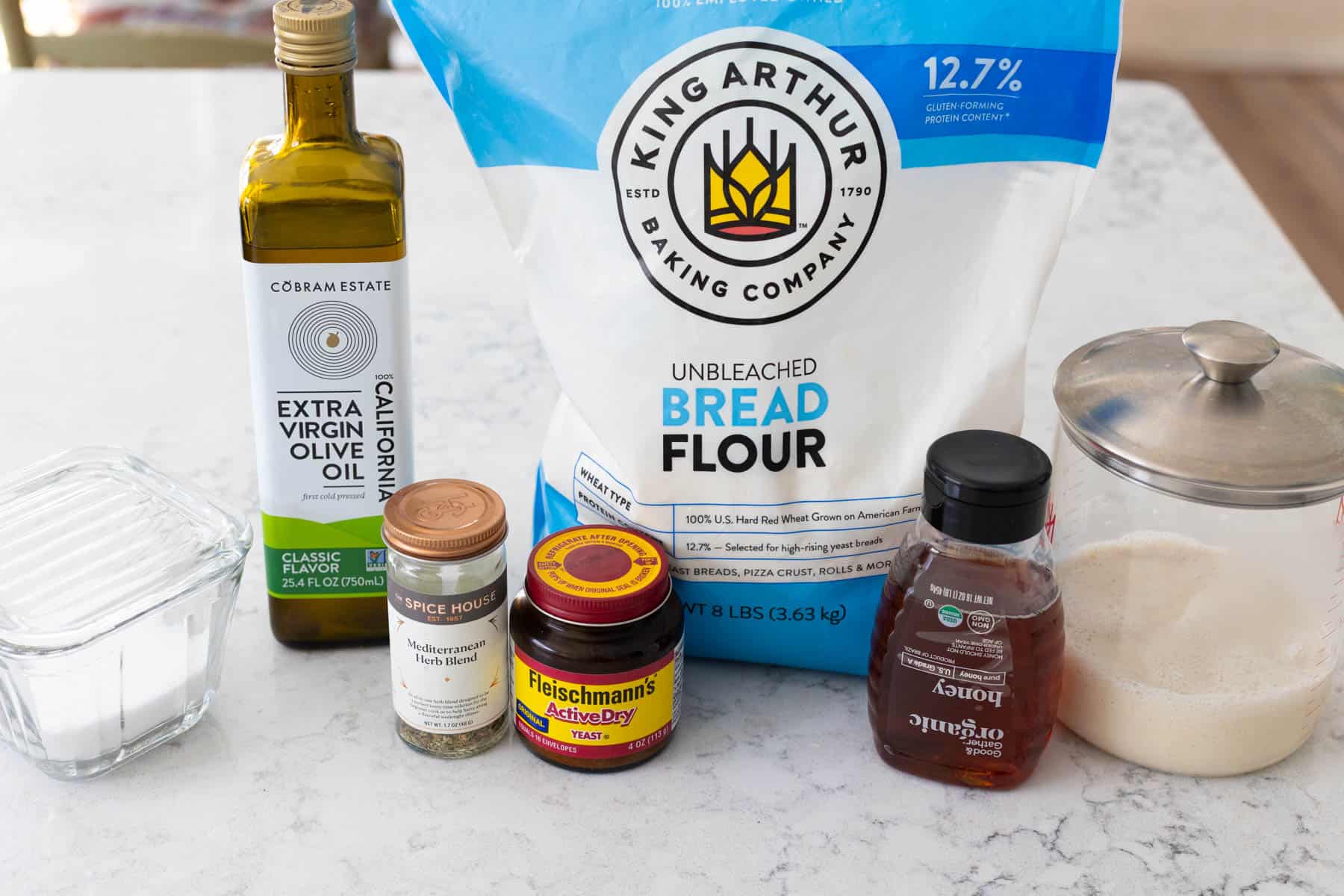 The ingredients to make sourdough focaccia sit on the kitchen counter.