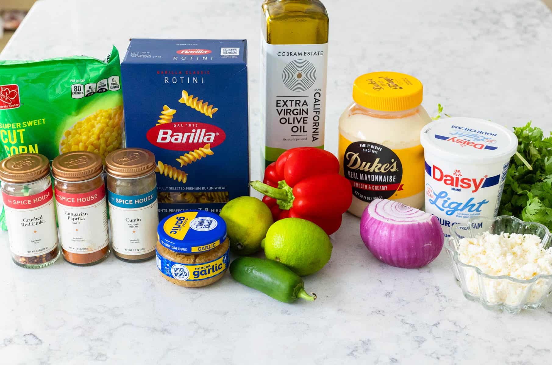 The ingredients to make Street Corn Pasta Salad are on the kitchen counter.