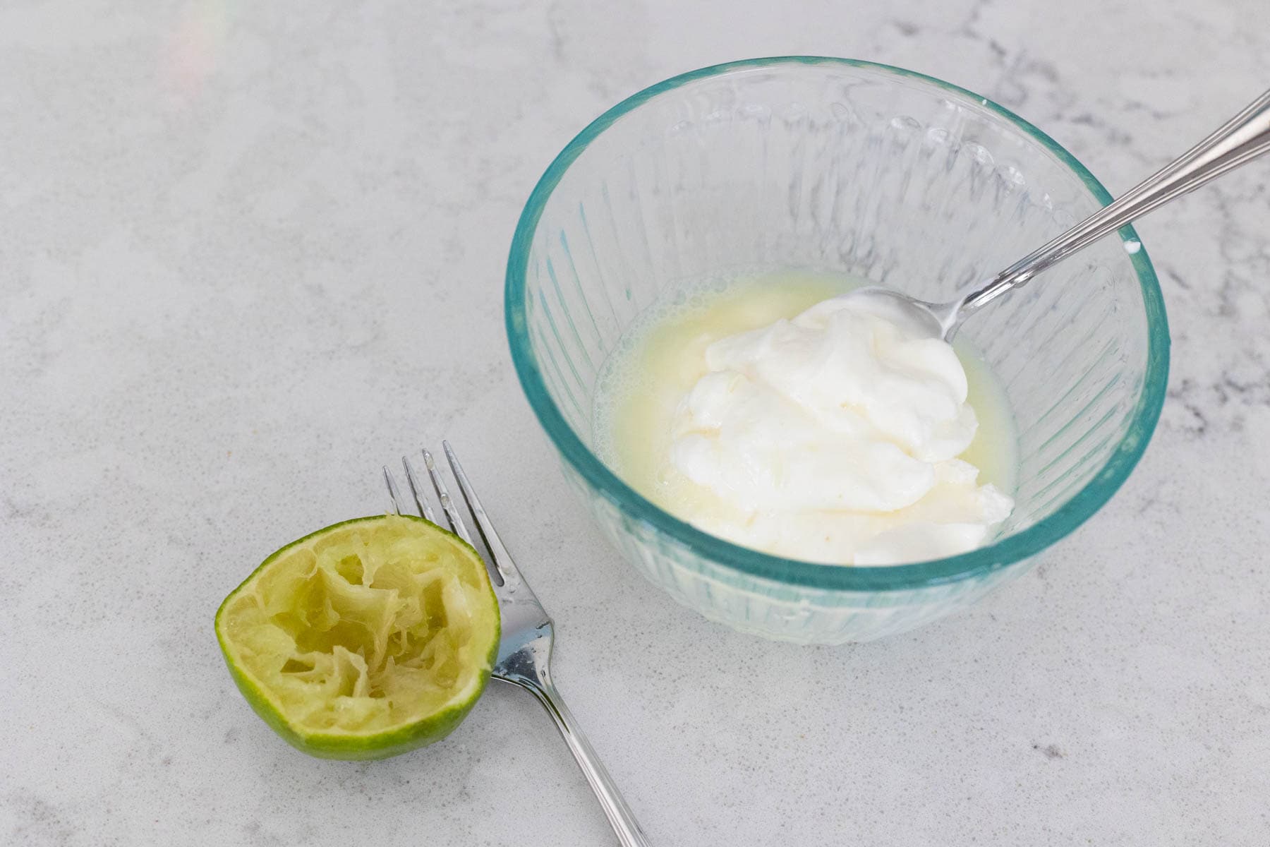 The ingredients to make Cilantro Lime Crema are on the kitchen counter.