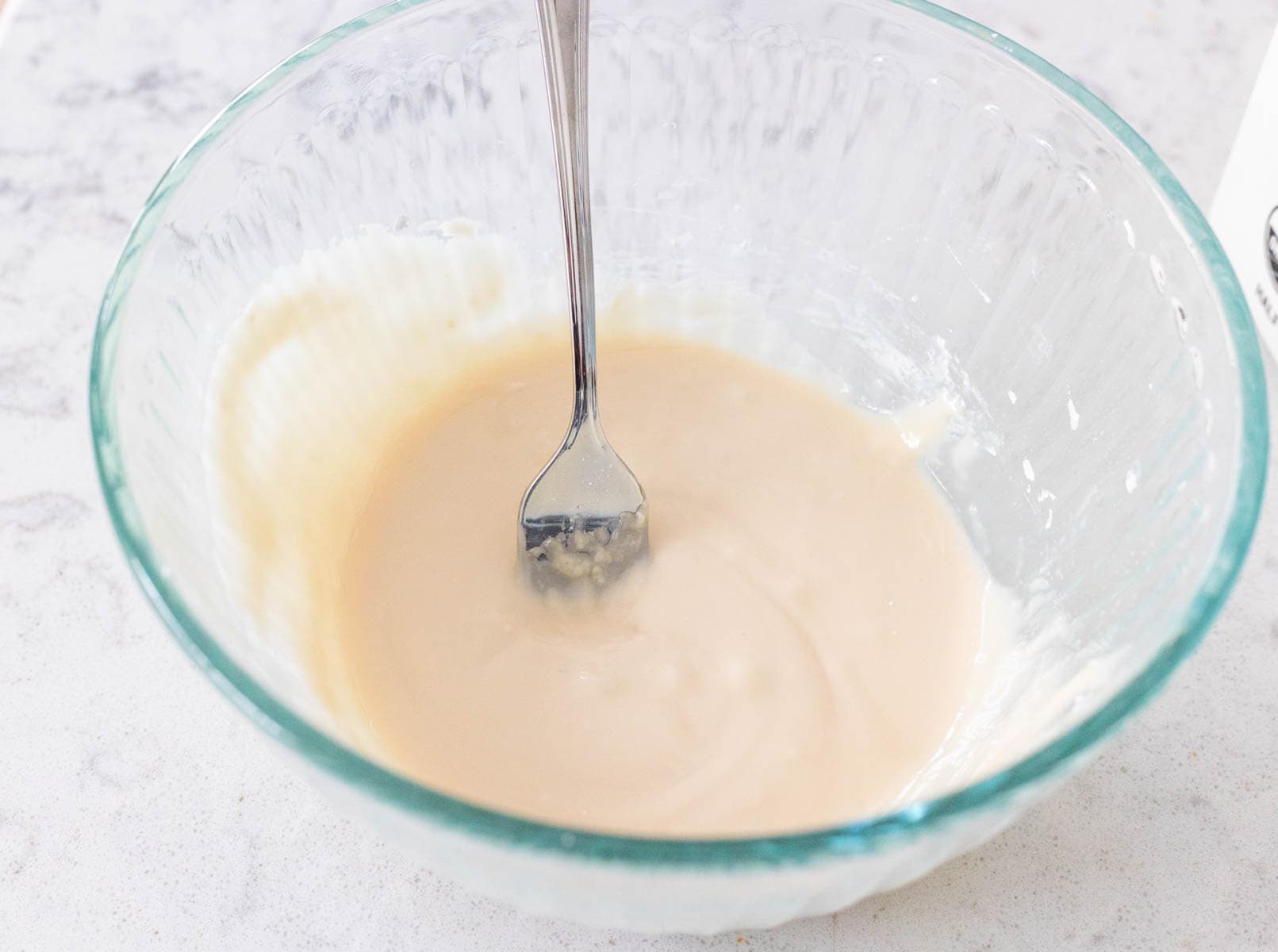 How to prep the maple glaze by mixing ingredients into a smooth, creamy consistency in a glass bowl.