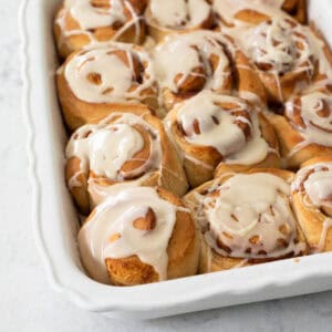 A baking pan of breakfast rolls has been drizzled with maple glaze.