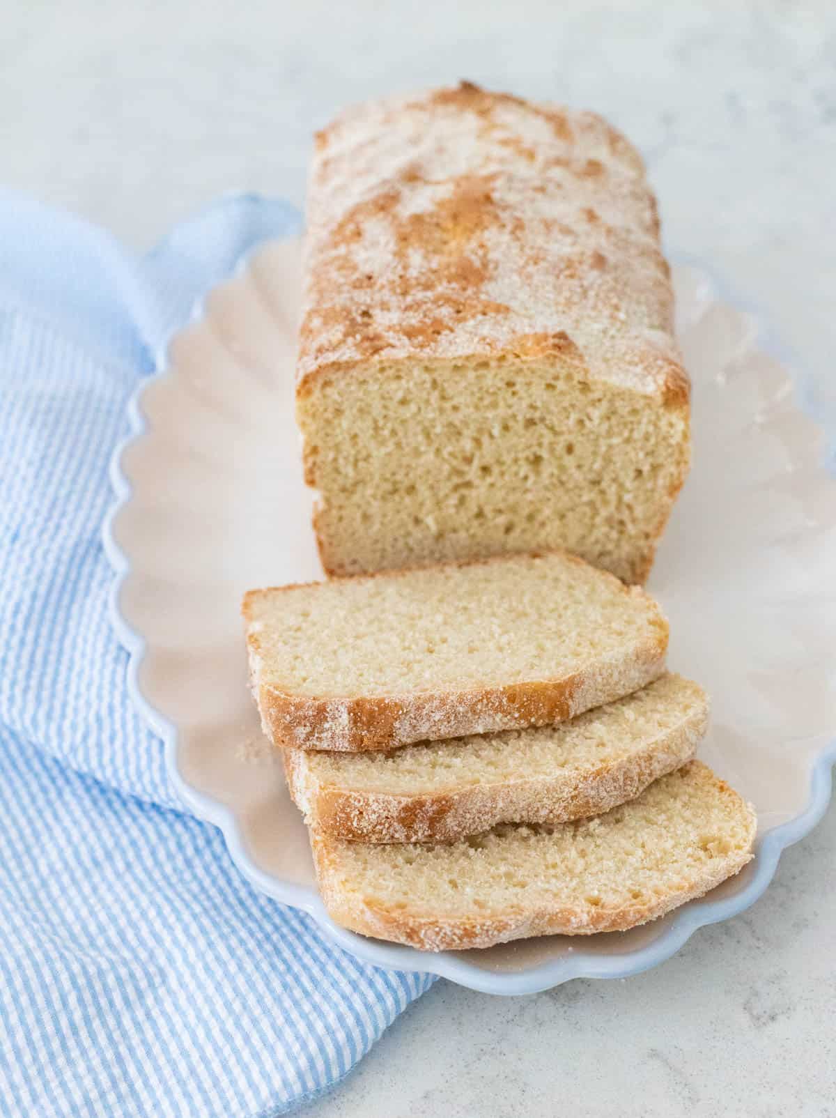 A loaf of English muffin bread has been sliced and served on a ruffled platter.