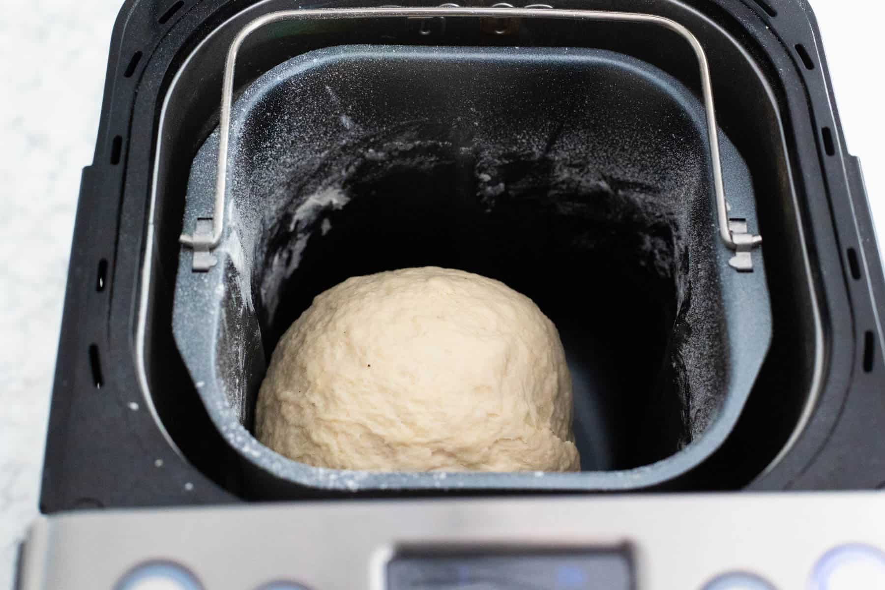 French pear bread dough forming into a smooth ball inside the bread machine during the kneading cycle.
