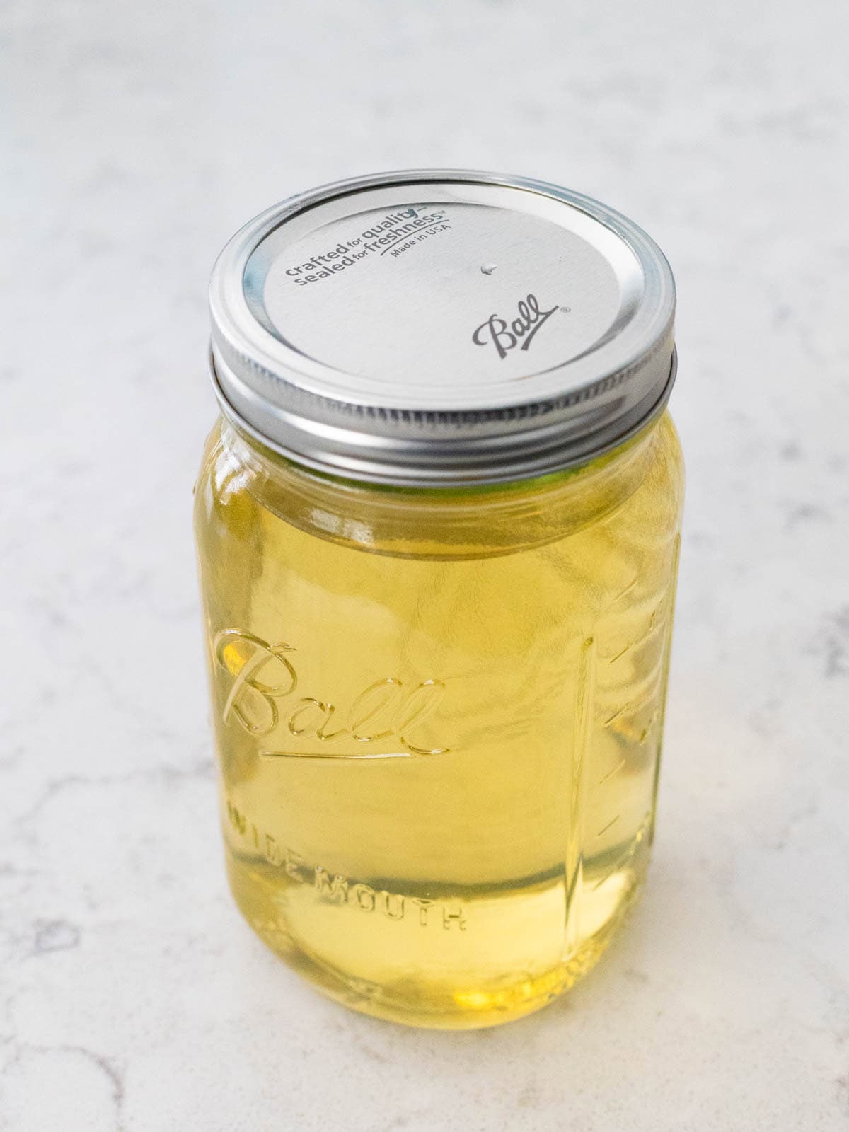 Un bocal en verre scellé rempli de limoncello au citron Meyer terminé, prêt à être refroidi et servi.