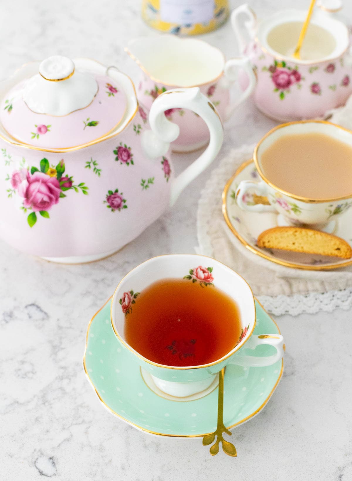 The tea party scene has one tea cup filled with black tea and another cup filled with milky tea.