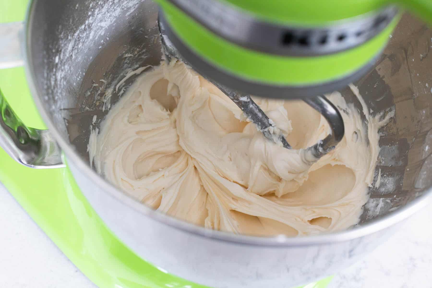 The milk and vanilla have been added to the mixer to smooth out the frosting.