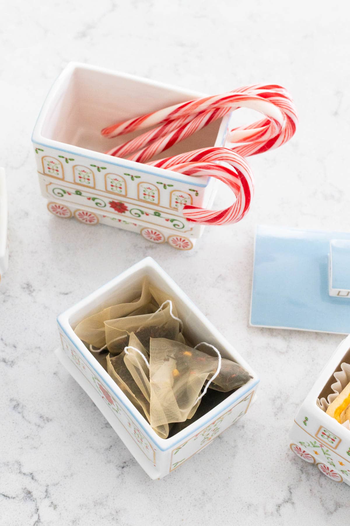 The serving pieces are filled with candy canes and tea bags.